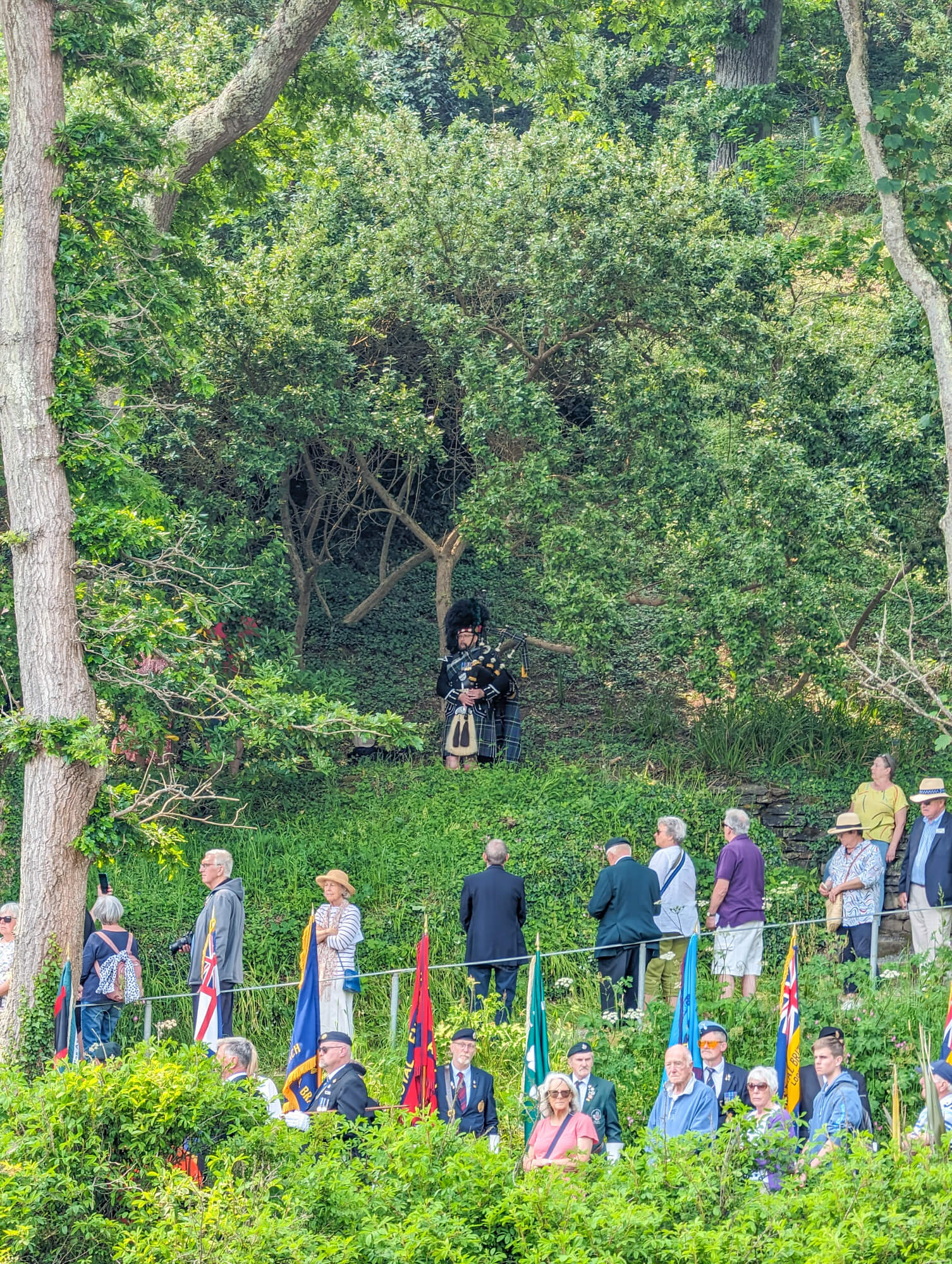A piper plays in the garden during the memorial service
