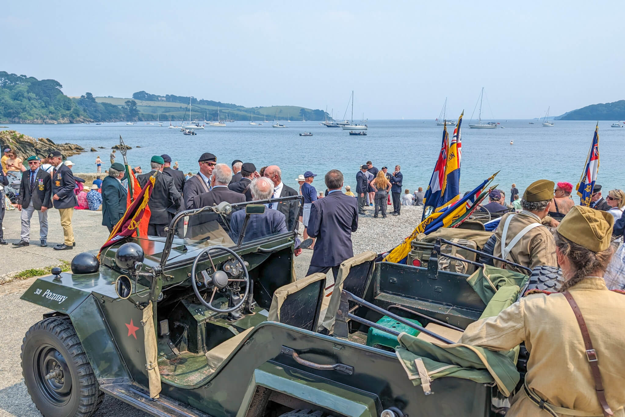 Standard bearers, military vehicles and visitors on Trebah Beach