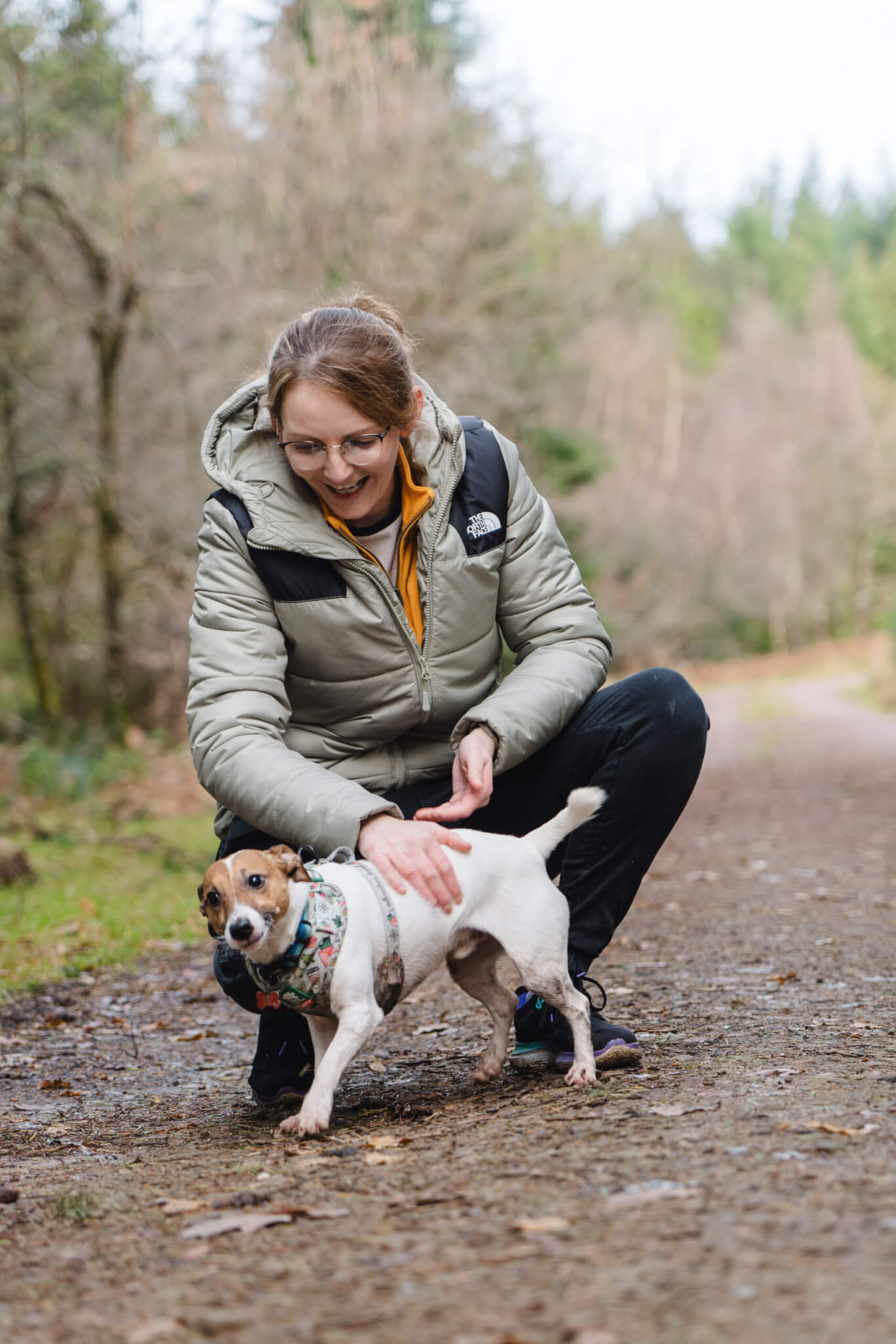 An owner stroking their small dog on a forest road (credit Forestry England – Crown Copyright)