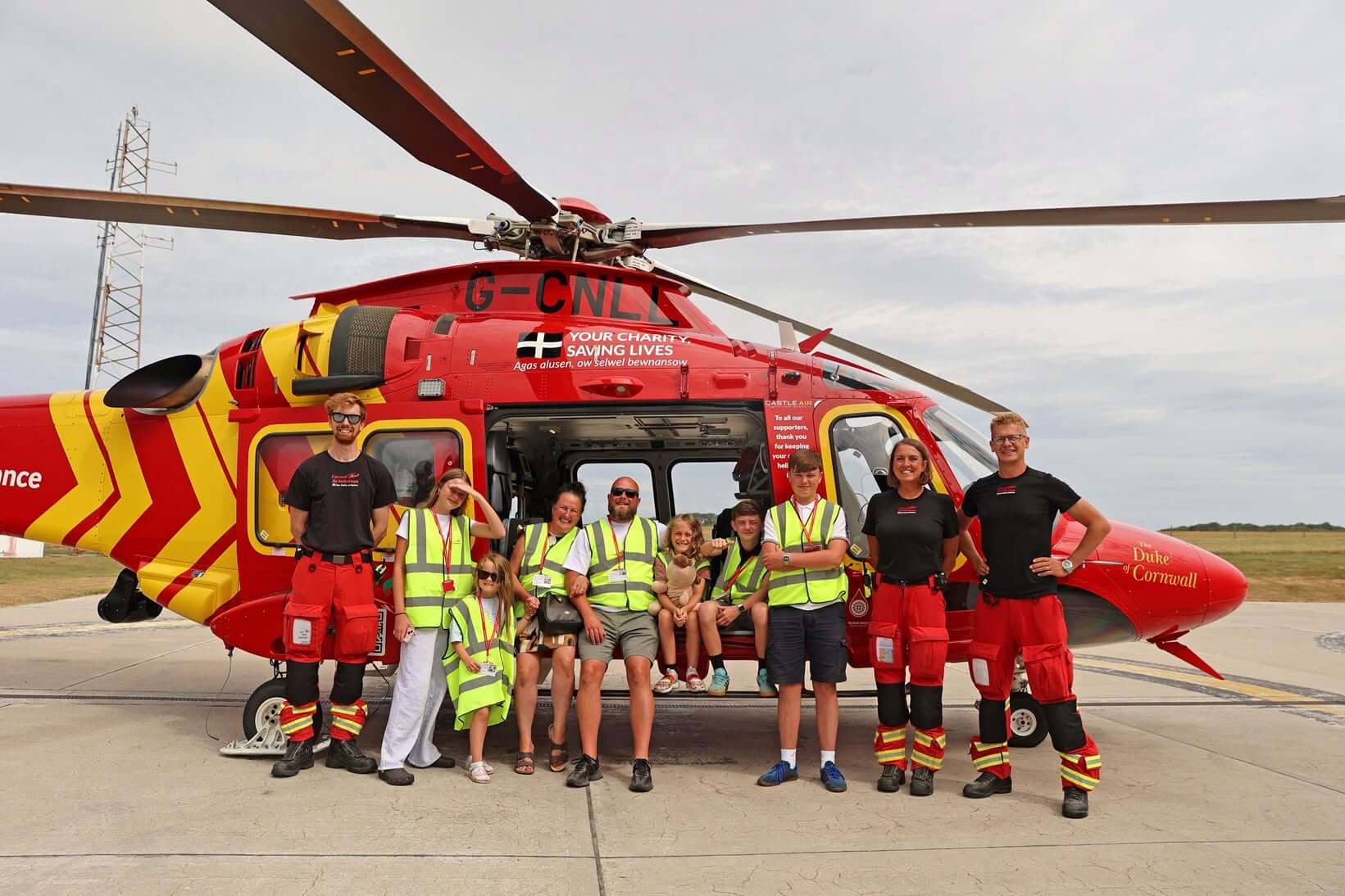 Freddie and his family stand with Cornwall Air Ambulance crew members beside the charity's AW169 helicopter