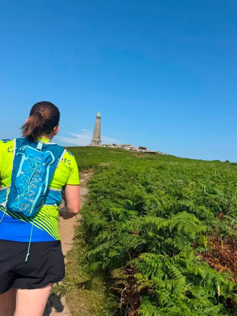 A Carn Runner heading up the path towards the monument on Carn Brea through the ferns