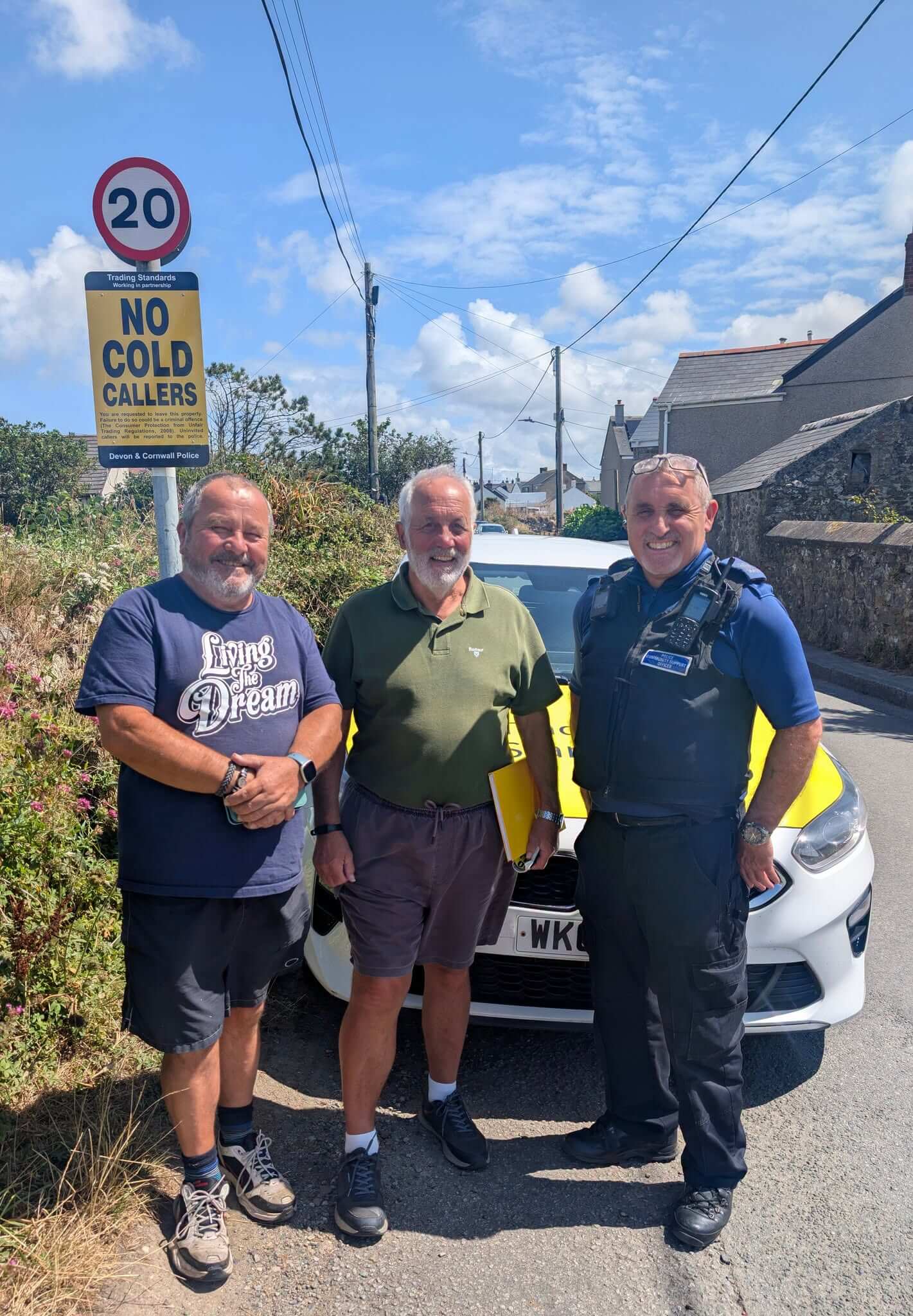 Two local residents stand with a police community support officer beside a No Cold Callers sign in one of Cornwall's new No Cold Caller Zones