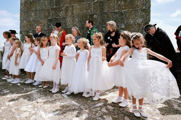 The maids line up with the Knill Trustees at the foot of the granite steeple