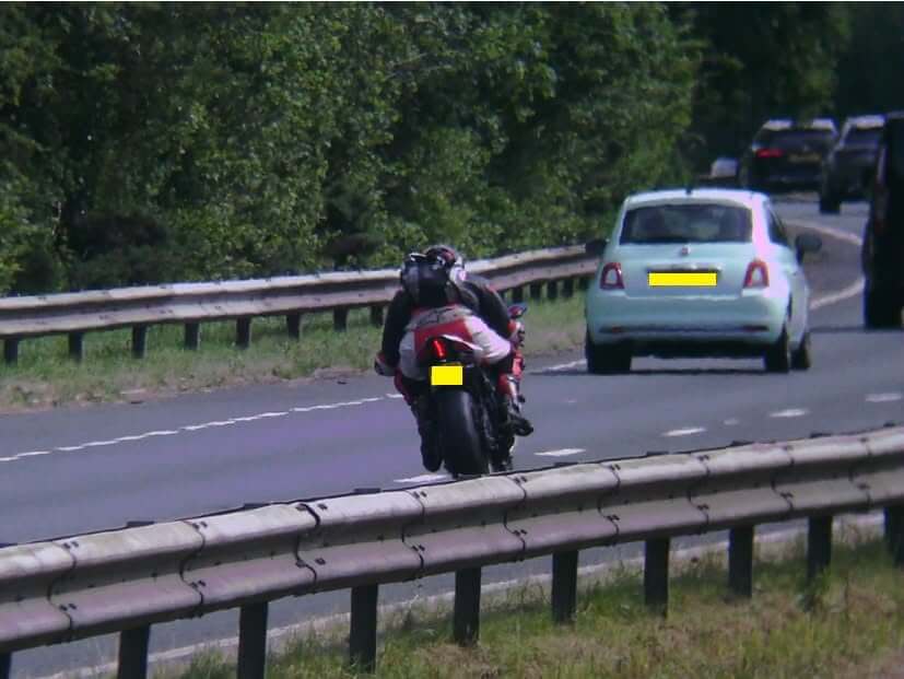 Rear view of a red sports motorcycle overtaking traffic on the A30 dual carriageway near Bodmin
