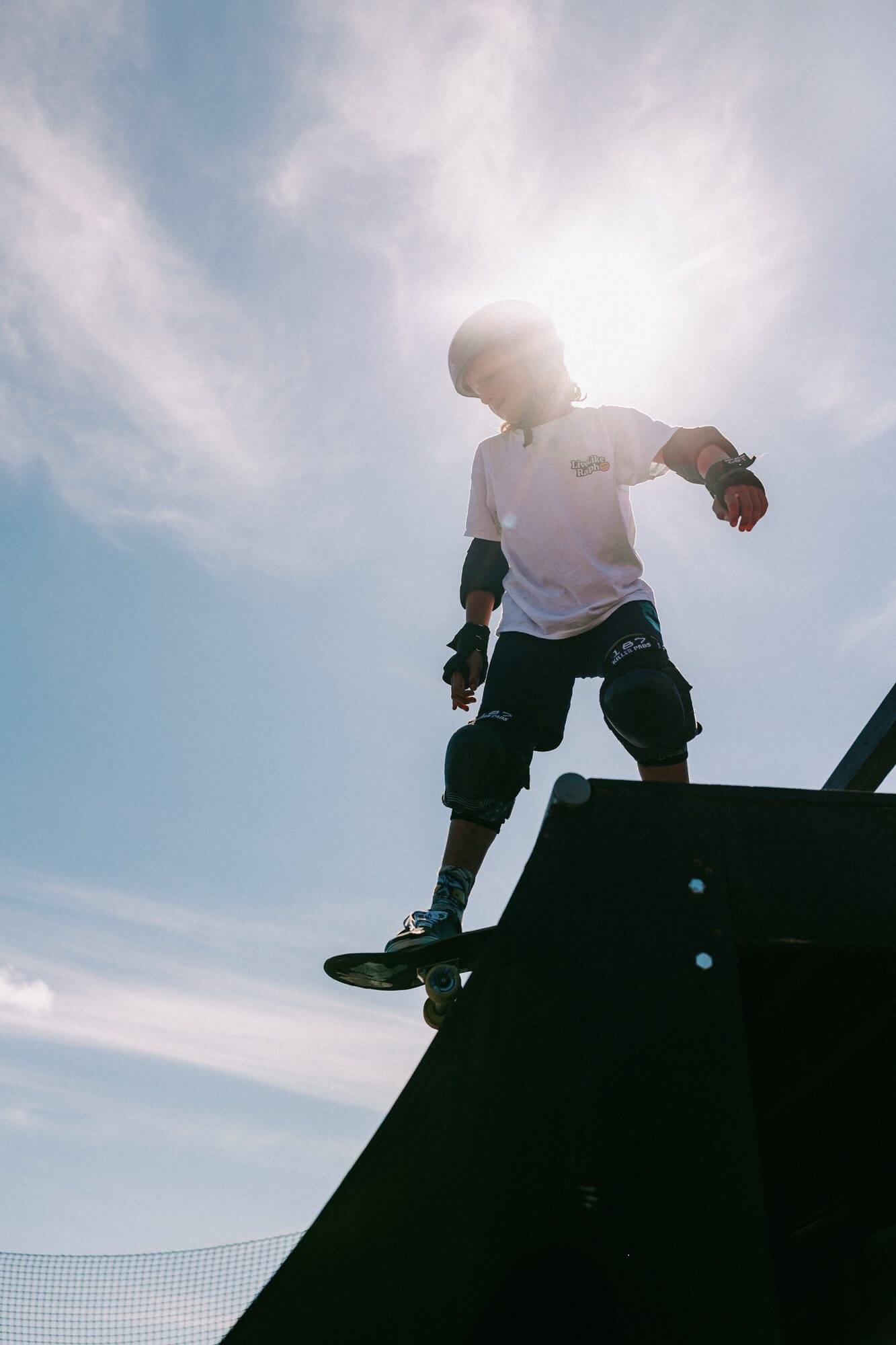 A young skater silhouetted against the sky at the top of the Boardmasters ramp