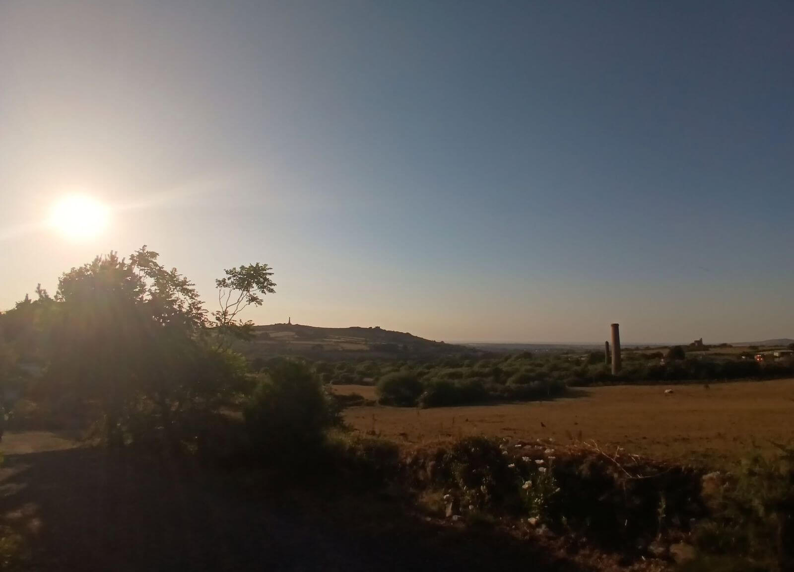Partial solar eclipse over a Cornish mine engine house at sunset