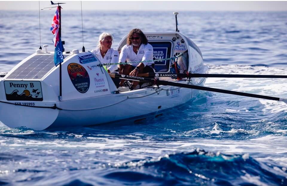 Dawn Smith and Paul Lore rowing their ocean boat across open water