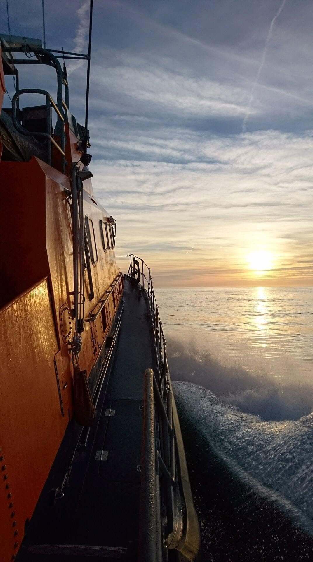 St Mary's RNLI all-weather lifeboat underway at sunset off the Isles of Scilly