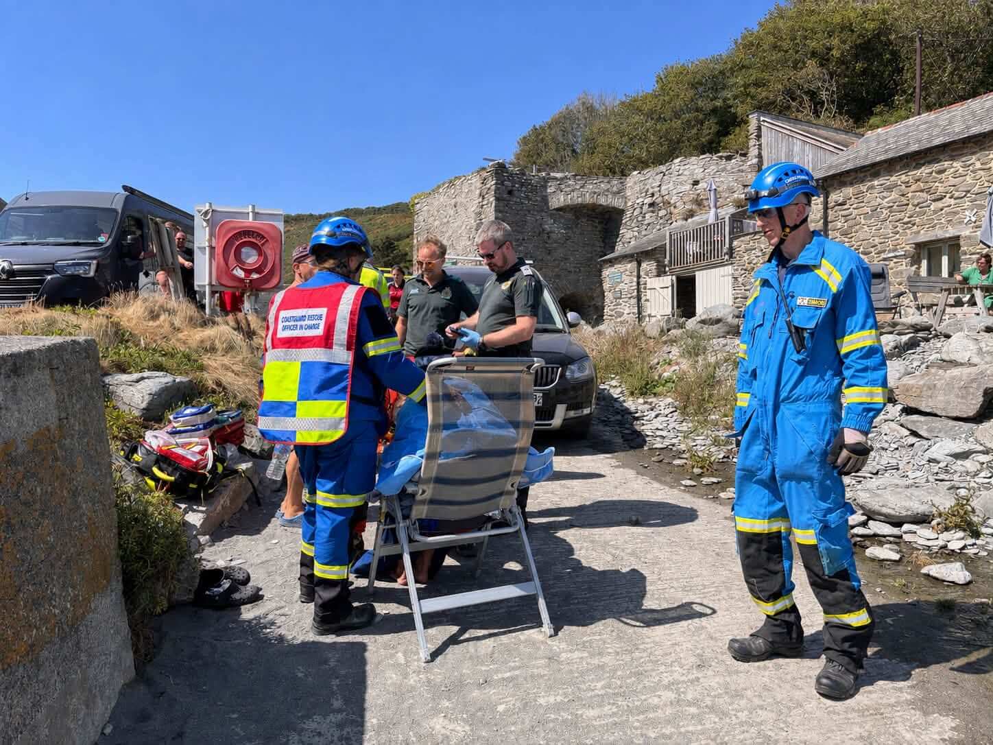 Coastguard rescue officer in charge and ambulance crew with a casualty at West Portholland