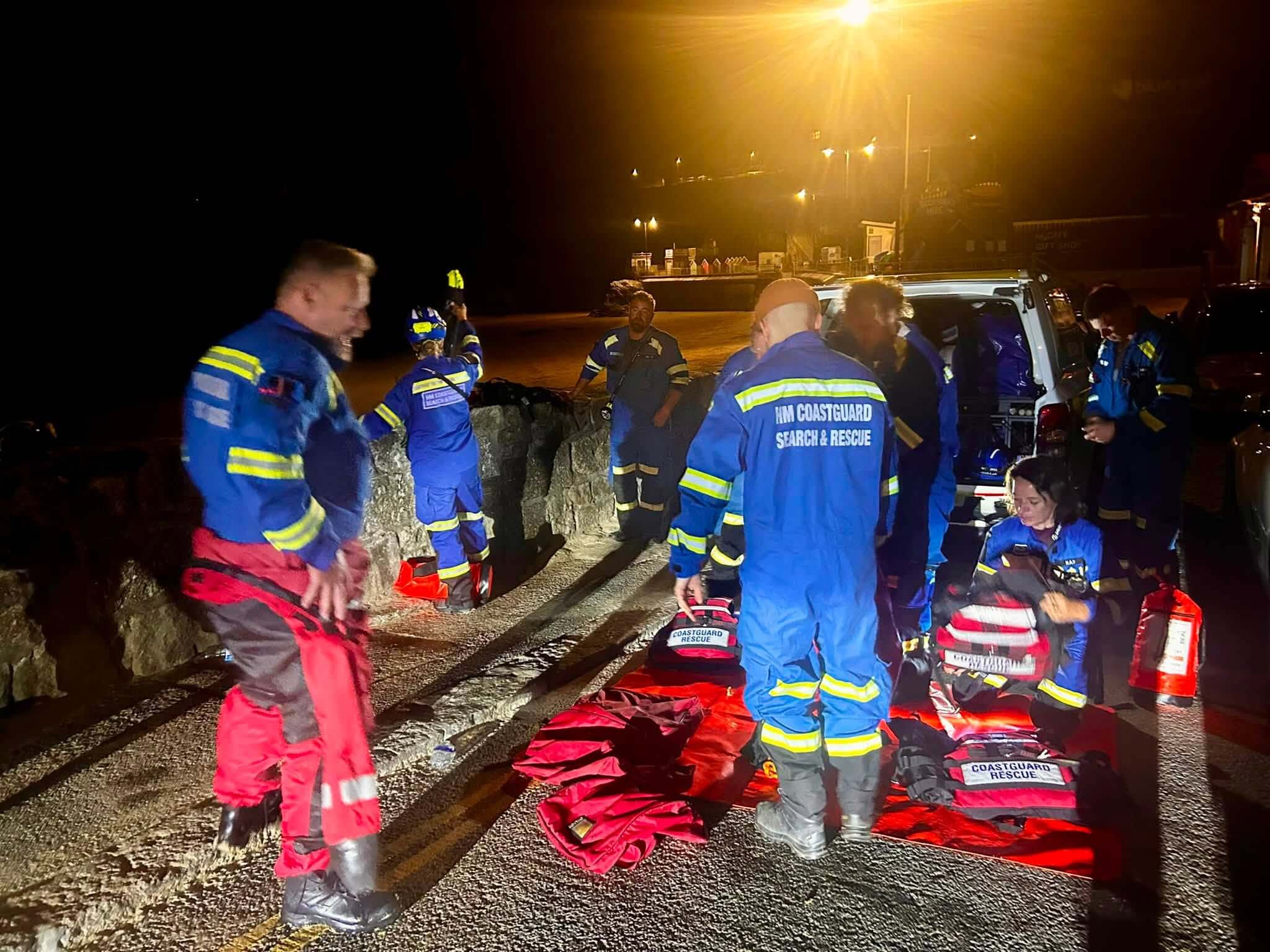 HM Coastguard search and rescue team members with their kit during a night callout in Newquay