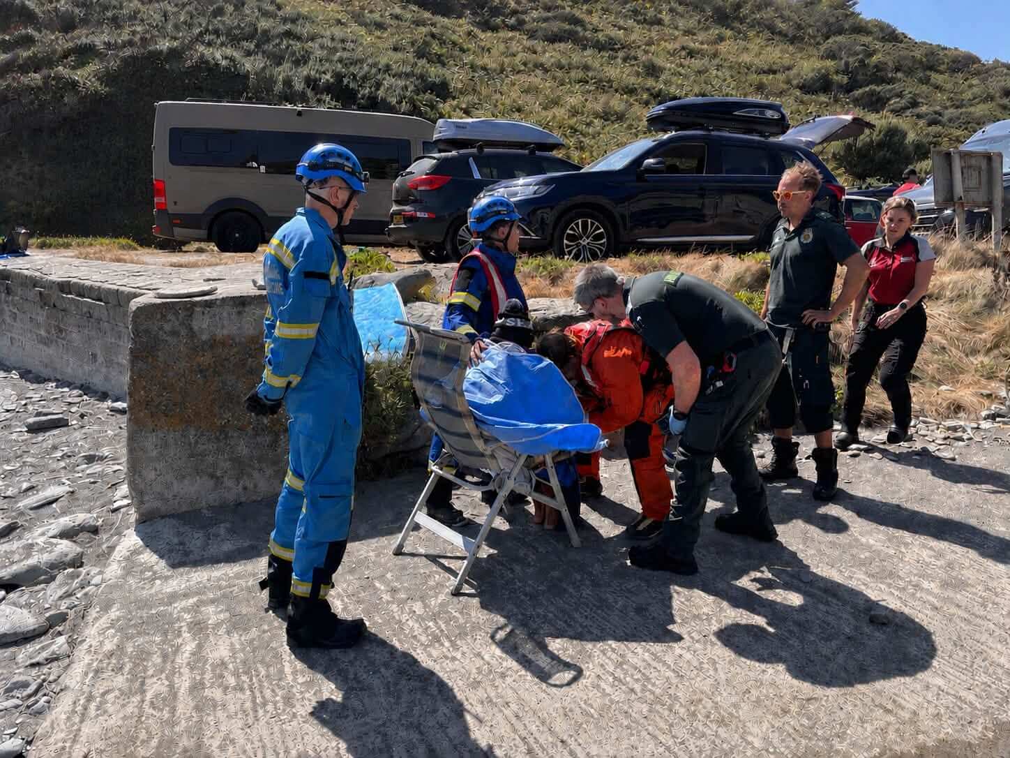 Coastguard and ambulance crews treating a casualty beside the beach at West Portholland