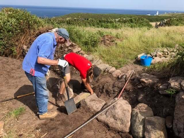 Cornwall Heritage Trust volunteers conserving a stone wall on the coast