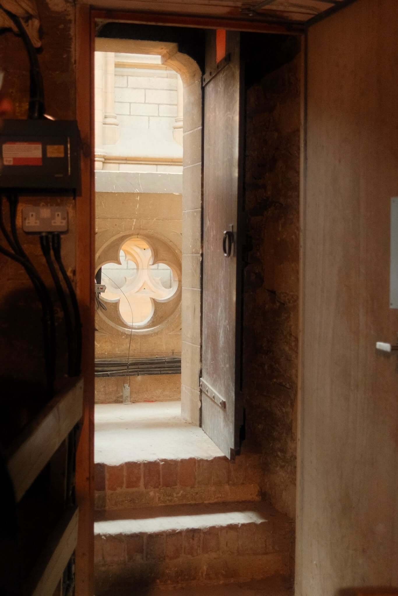 A doorway leading out to a quatrefoil window on the Truro Cathedral roof tour