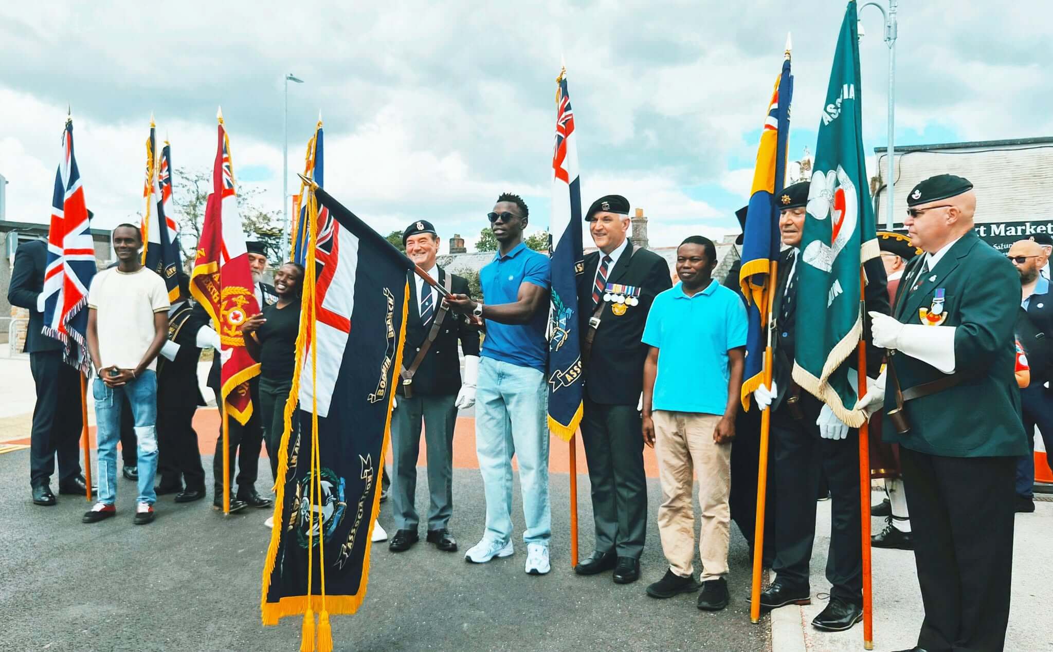 Standard bearers and community members with flags at the Liskeard parade