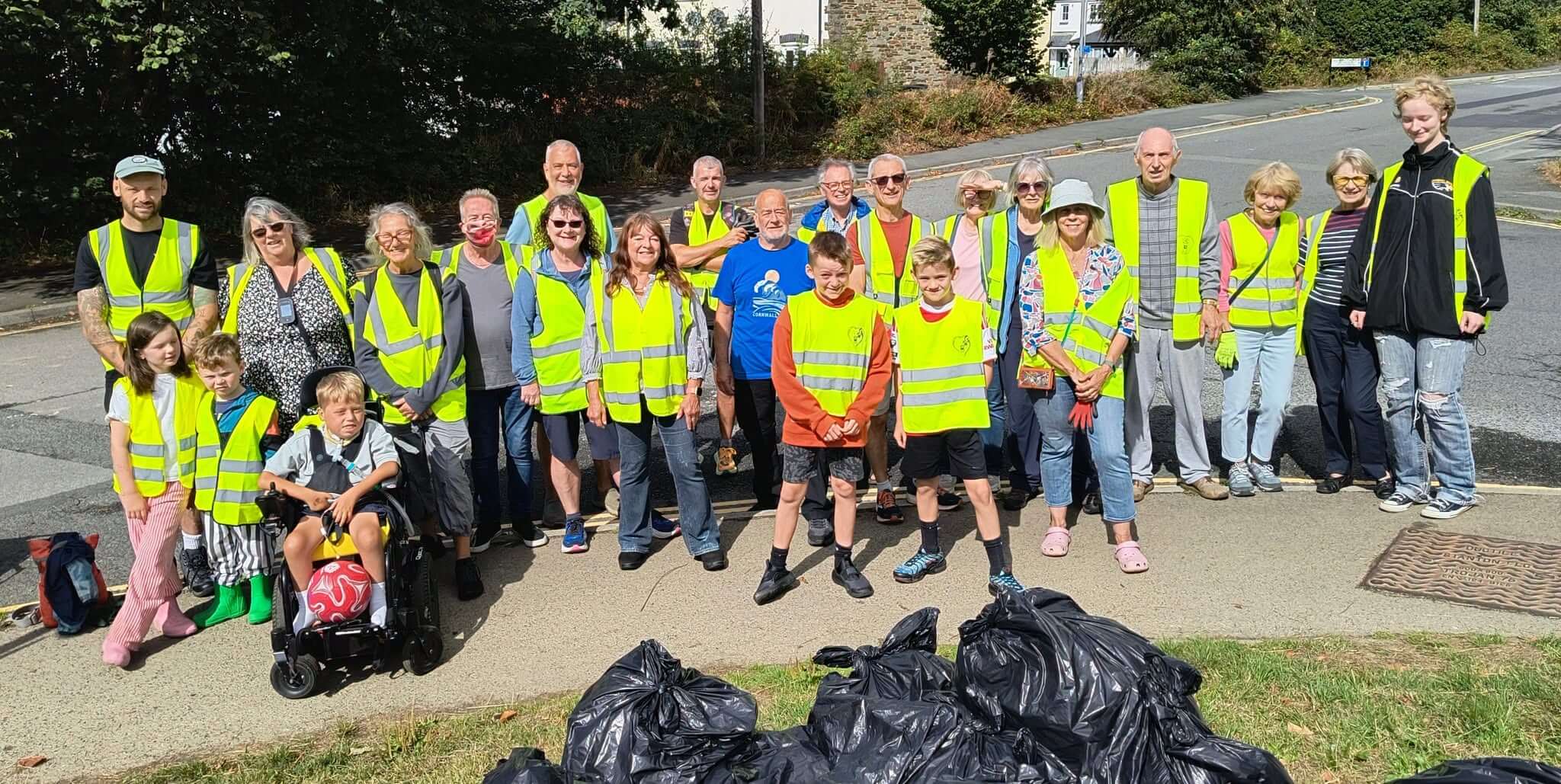 Bodmin Tidy It Team volunteers in hi-vis vests with bags of rubbish and recycling on College Lane