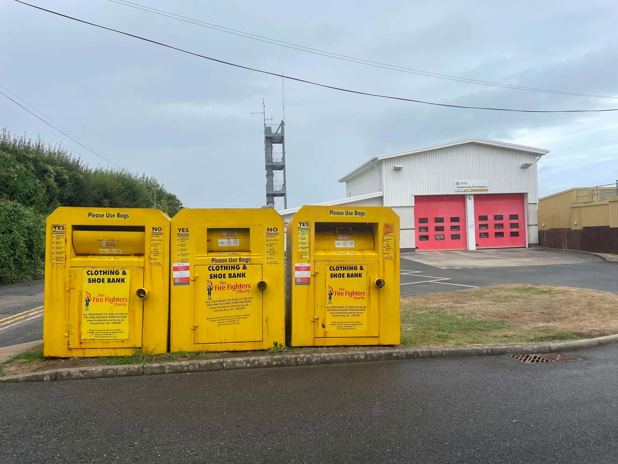 Three yellow clothing and shoe banks outside Wadebridge Community Fire Station