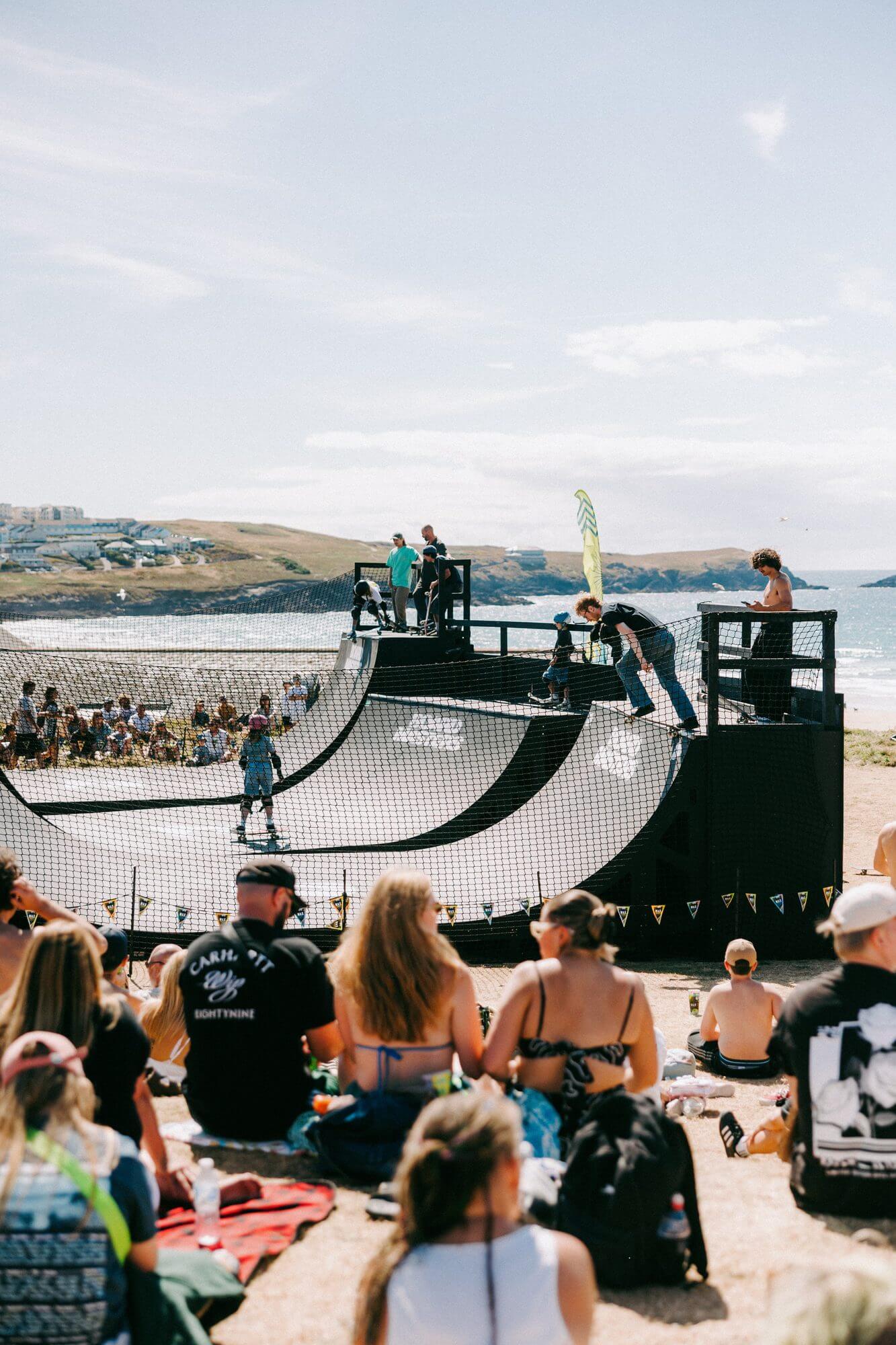 Crowds watch skateboarding on the mini ramp above Fistral Beach at Boardmasters