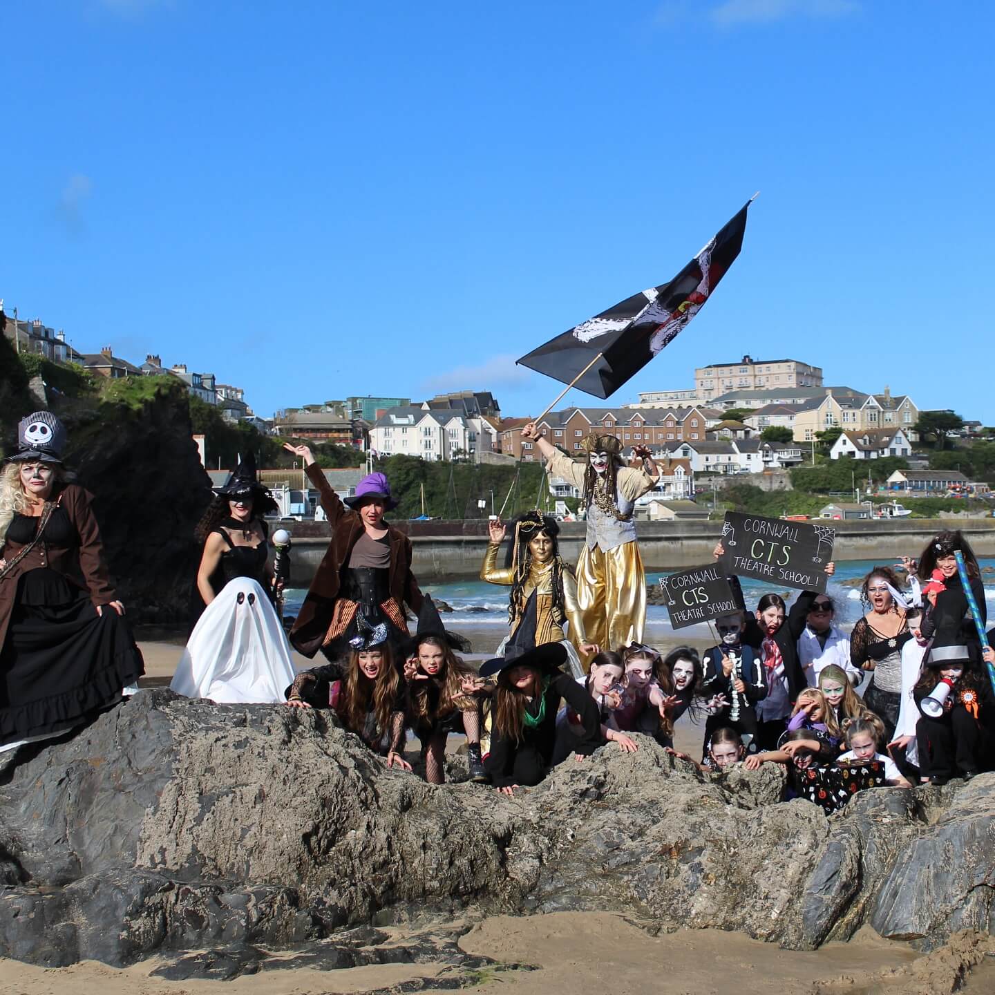 A group in Halloween costume pose on the rocks at Newquay beach