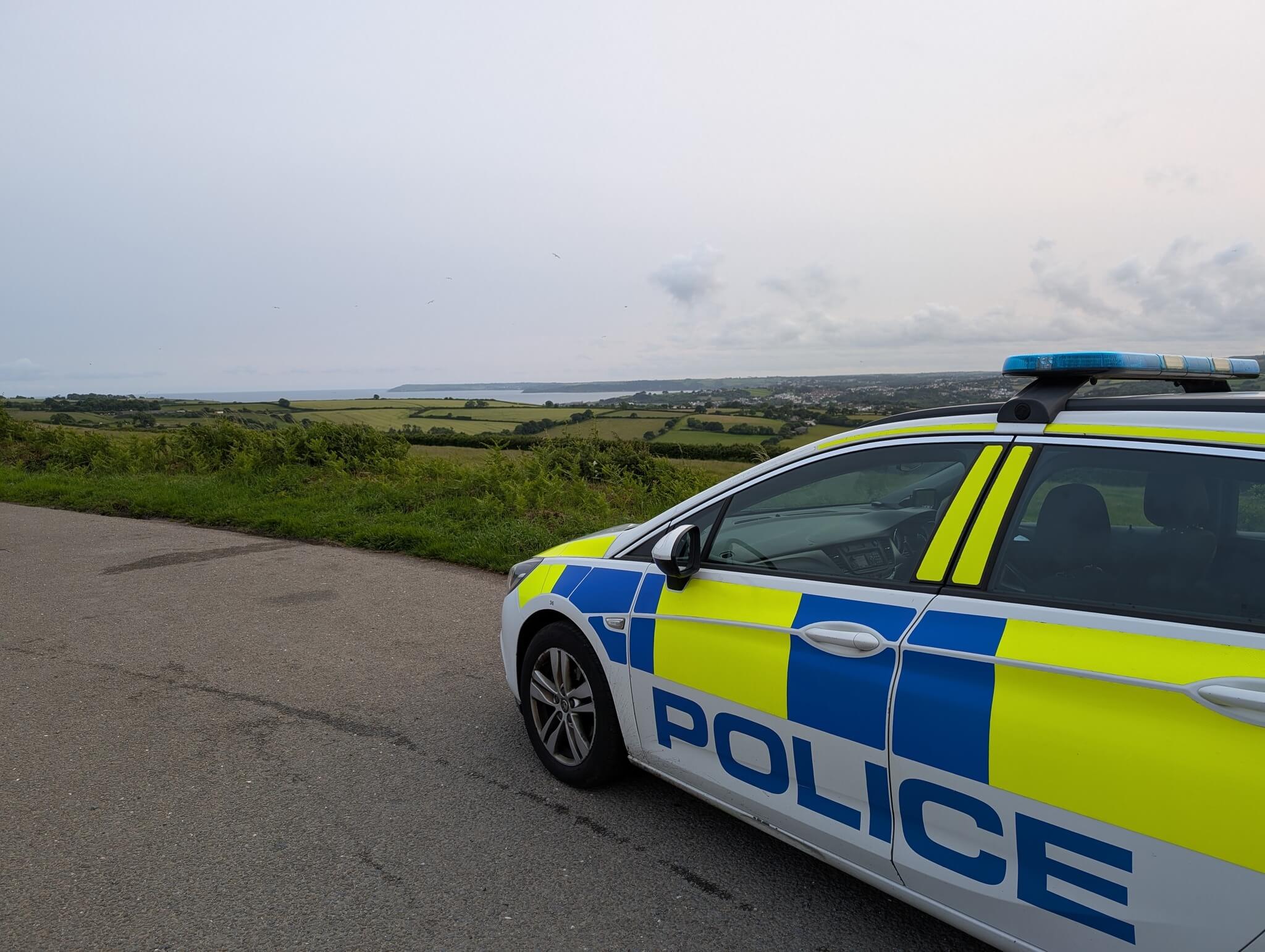 Devon and Cornwall Police car parked overlooking St Austell Bay