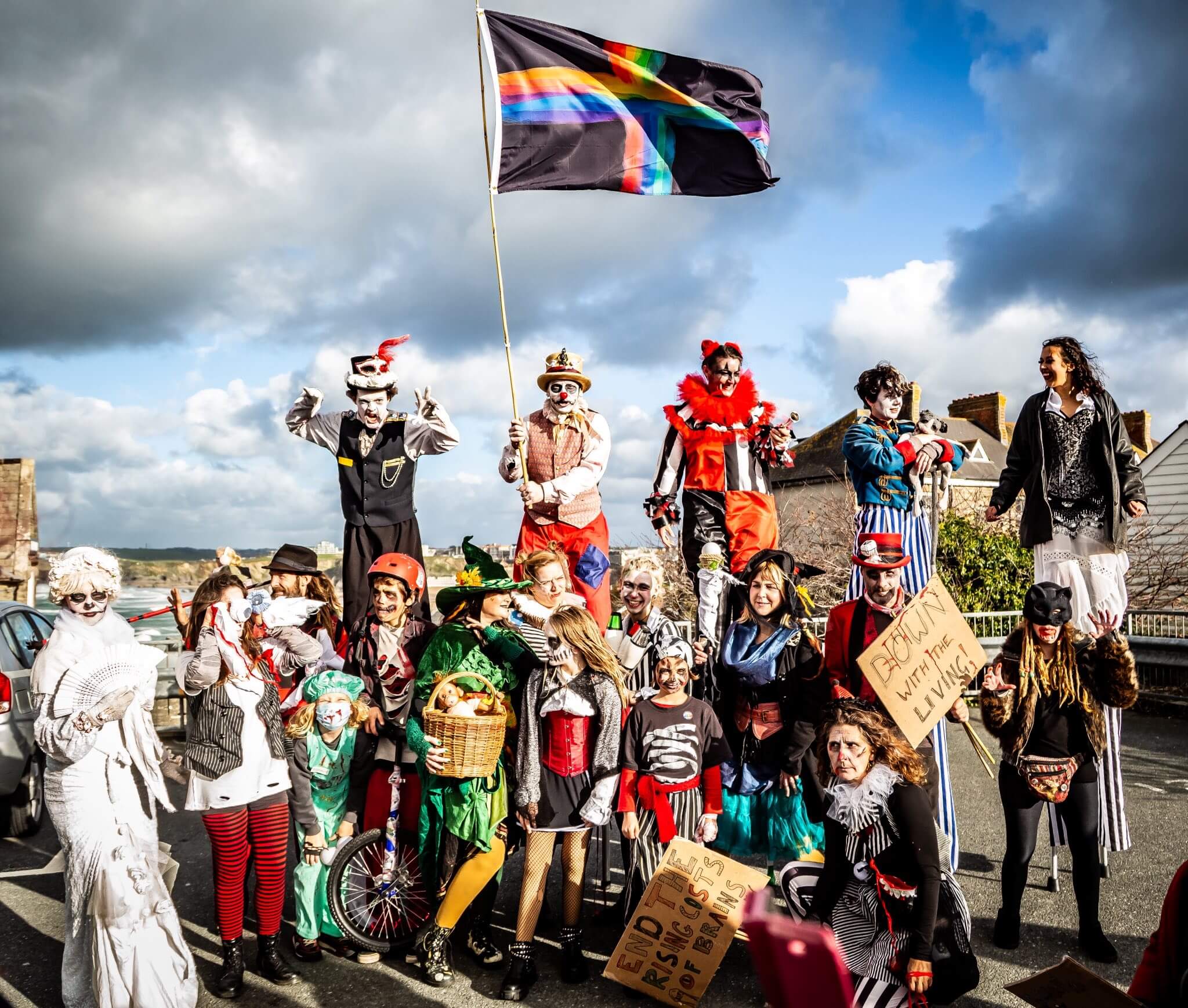 Stilt walkers and painted performers lead the flag at the Spooky Newquay Zombie Crawl