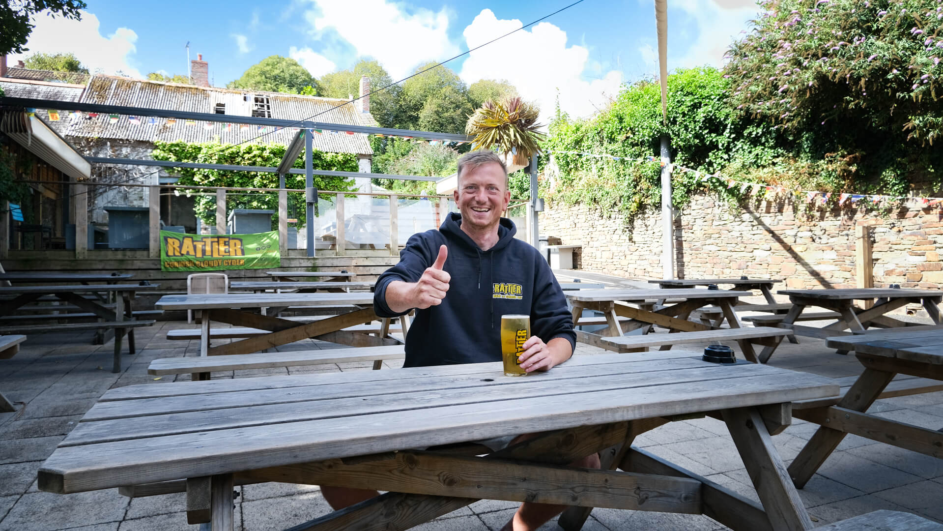 Fives Cyderhouse team member giving a thumbs up in the beer garden