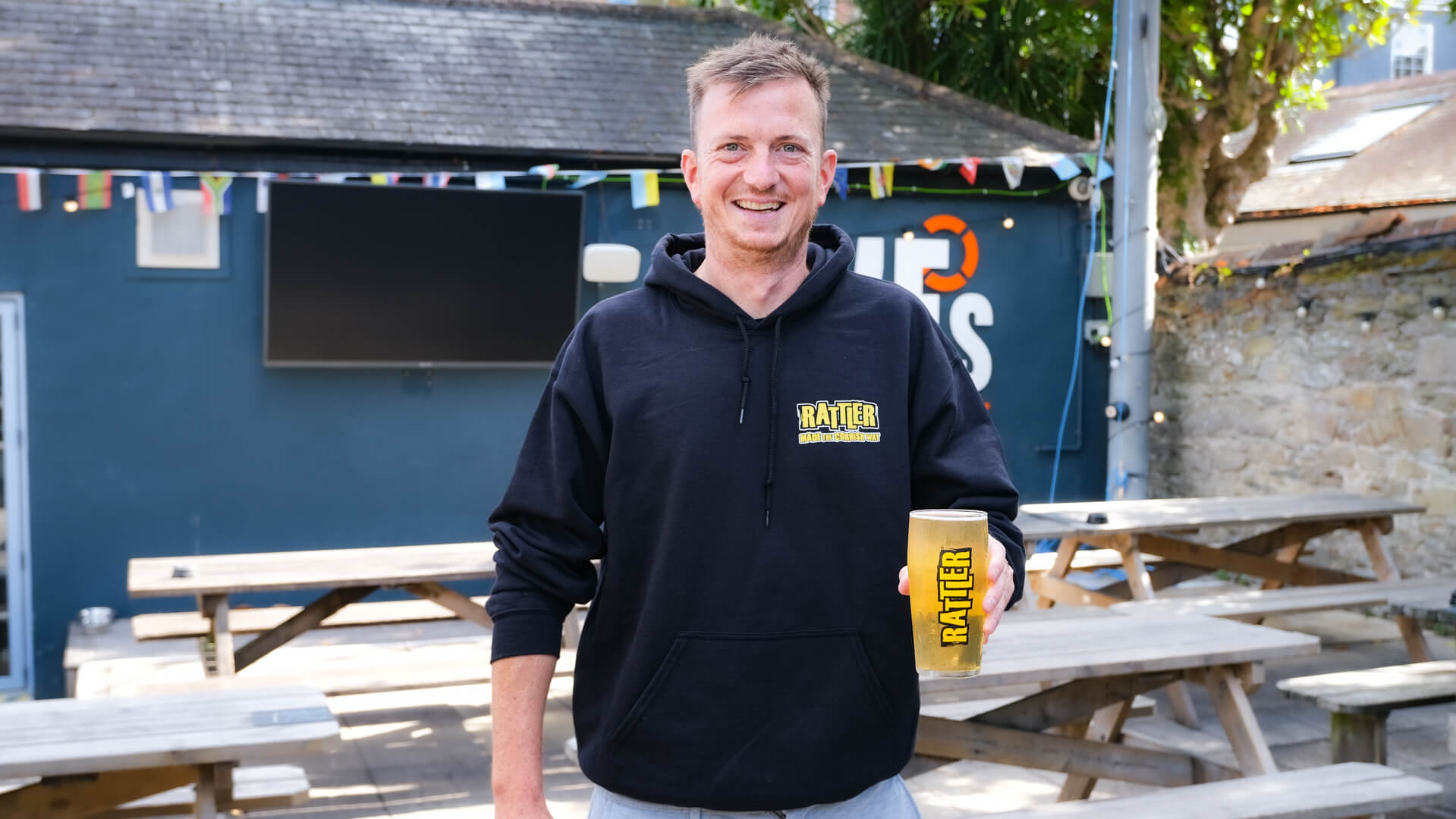 Fives Cyderhouse team member with a pint of Rattler Cyder