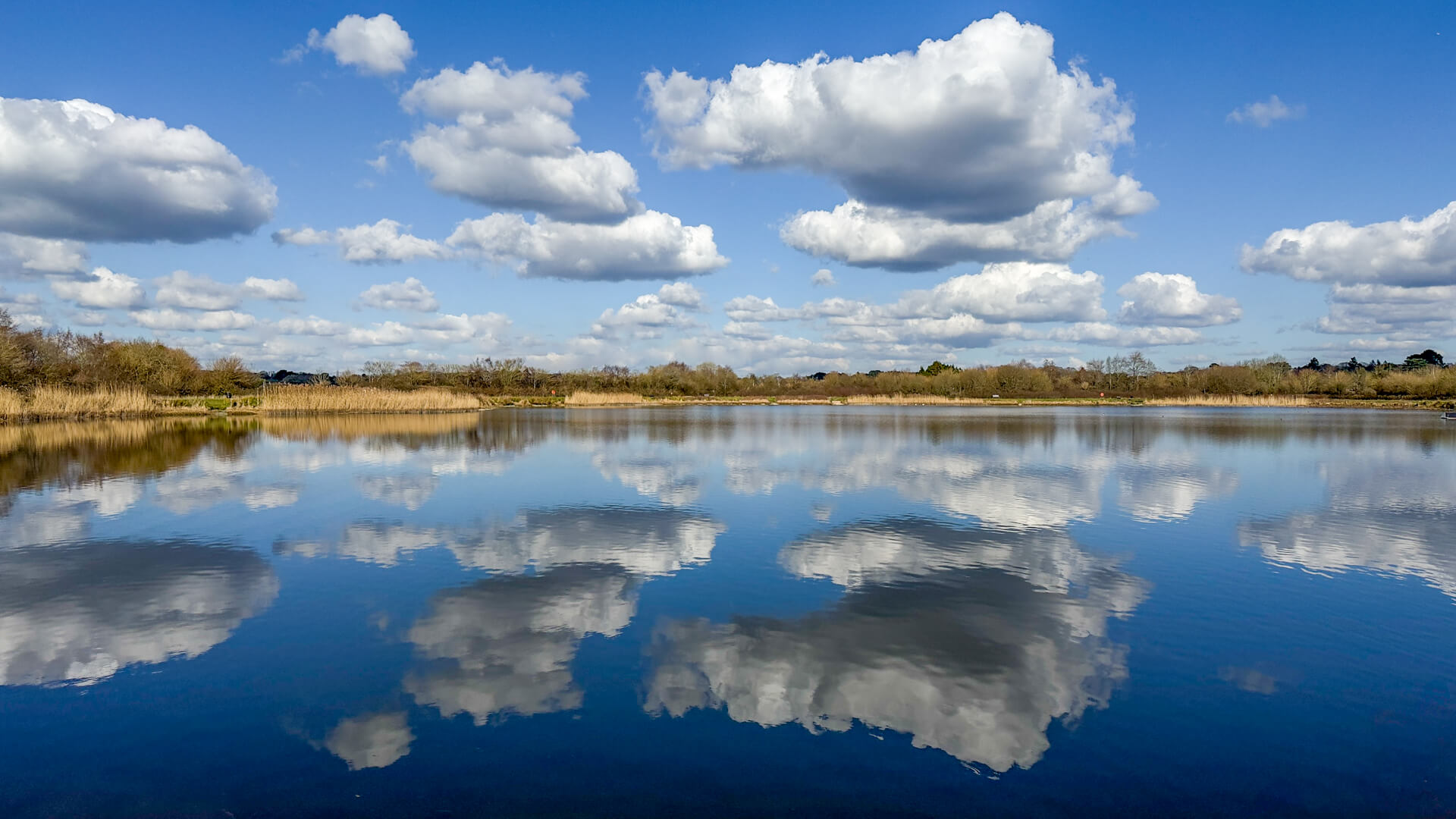 Clouds reflected in the still water of a lake managed by South West Lakes Trust