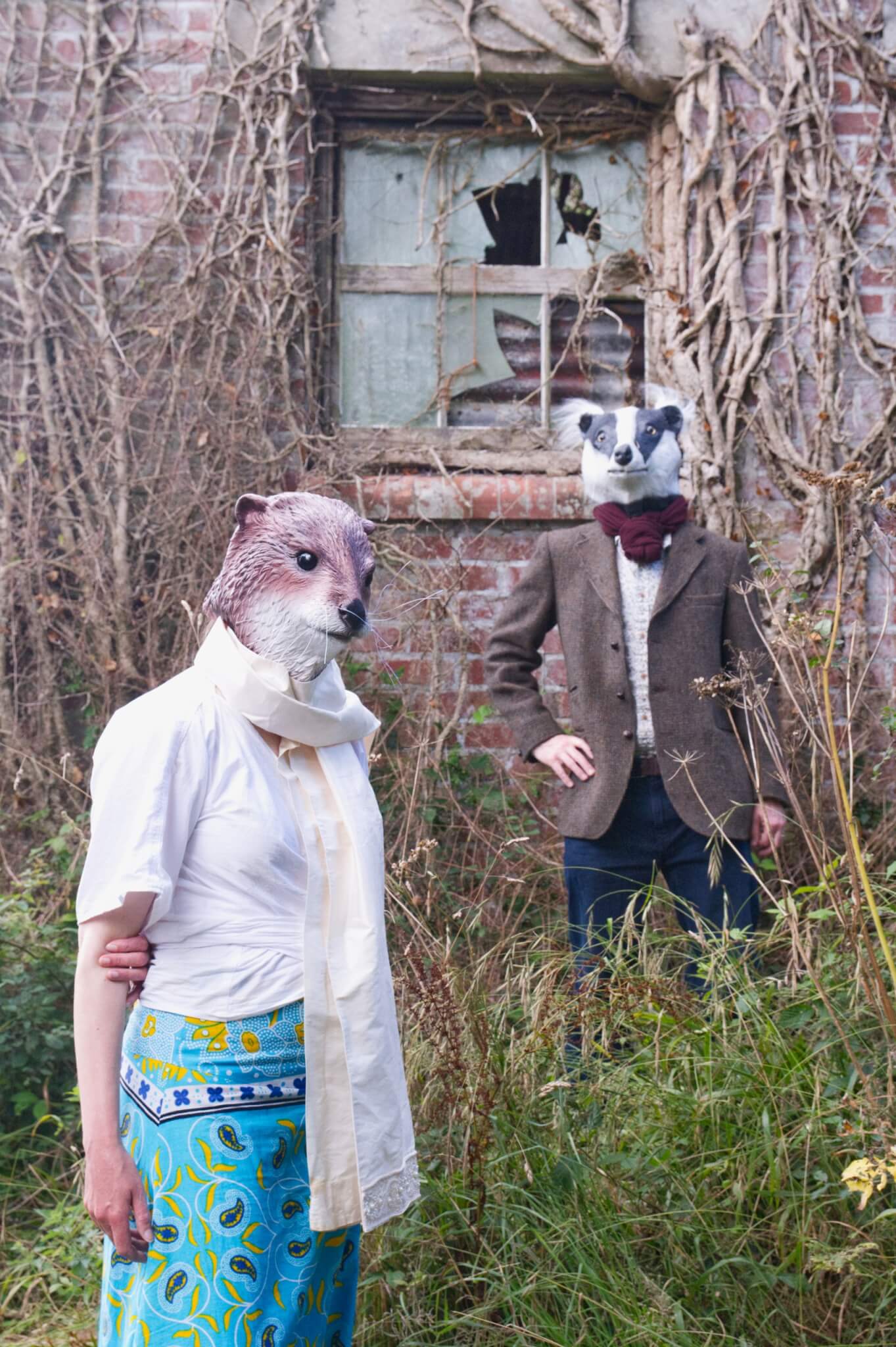 Meles Lutra in badger and otter masks on a green wooded Cornish path