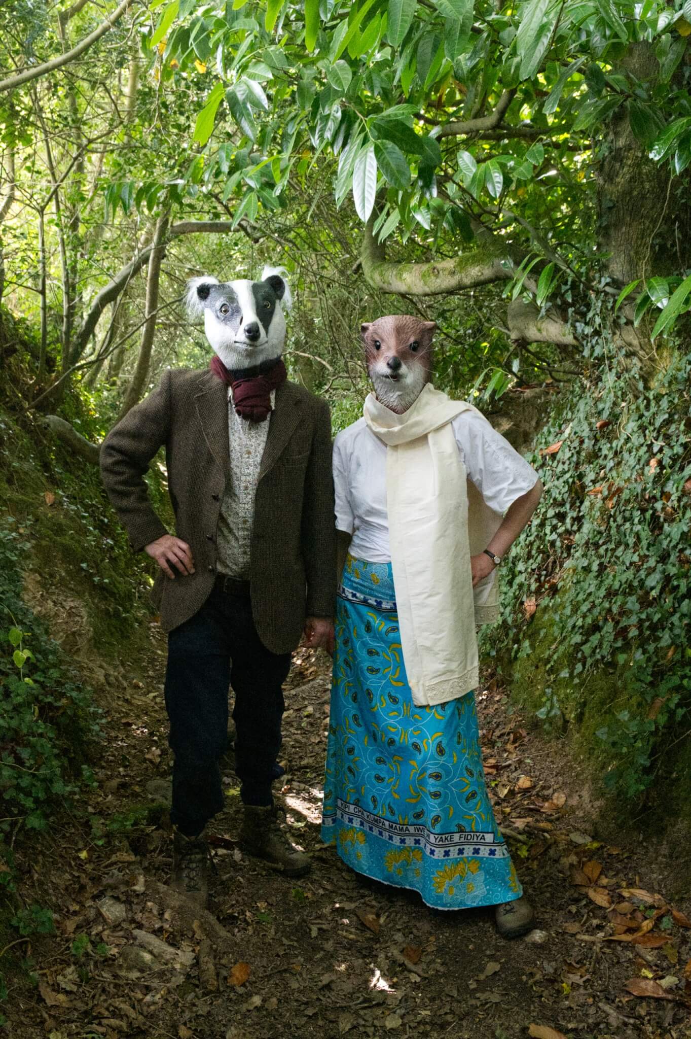Meles Lutra in otter and badger masks outside a derelict ivy-covered Cornish cottage