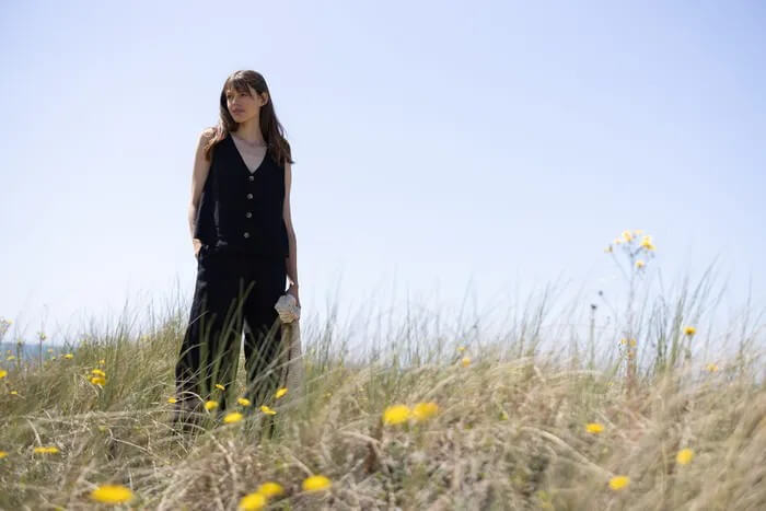 Woman in Nomads clothing standing in a grass field