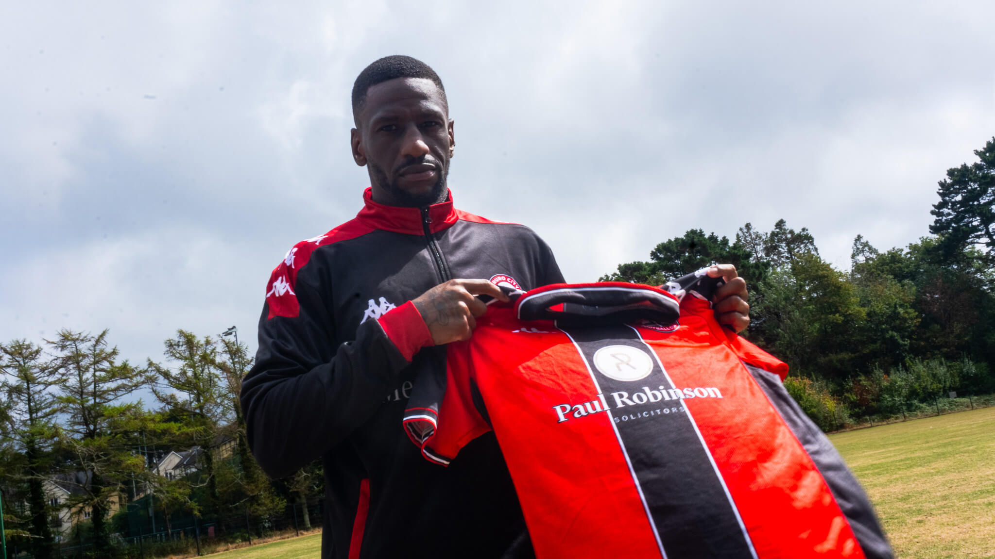 Omar Bogle holding a Truro City shirt