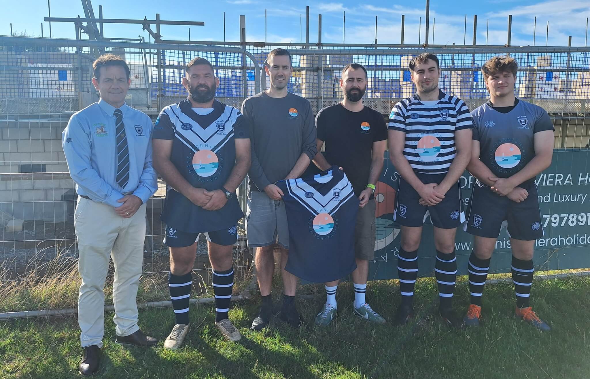 St Ives RFC players and Cornish Riviera Holidays directors in new kit by the clubhouse development
