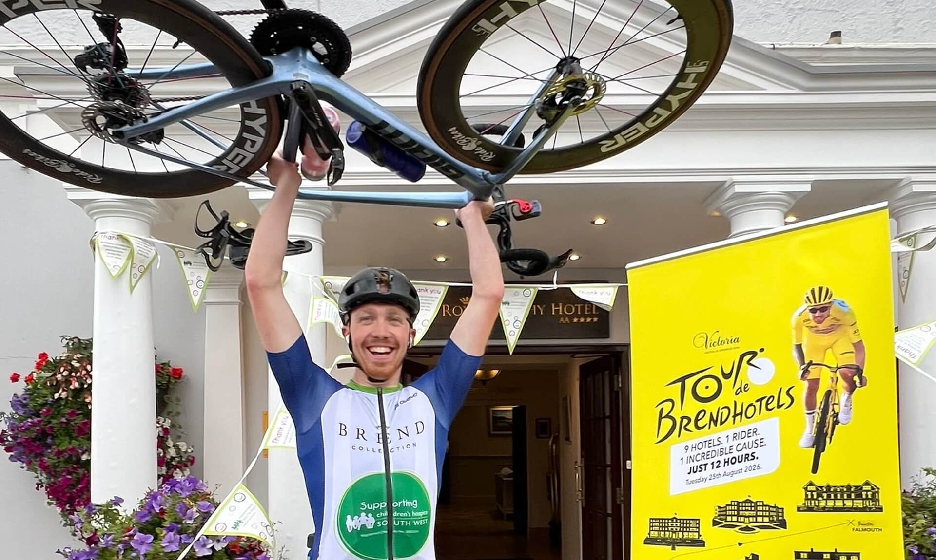 Aidan holding his bike aloft outside The Royal Duchy Hotel in Falmouth