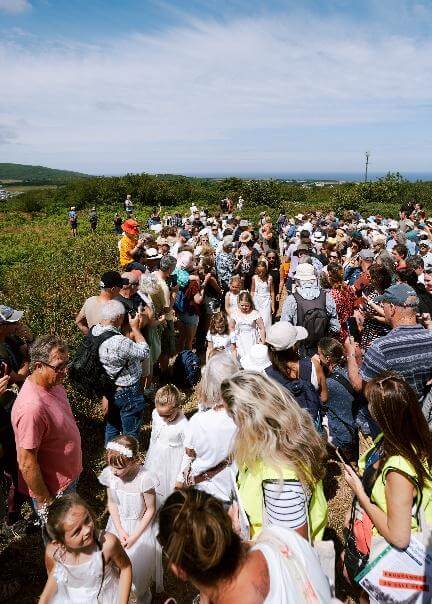 A large crowd gathers around Knill's Monument on Worvas Hill with the sea beyond