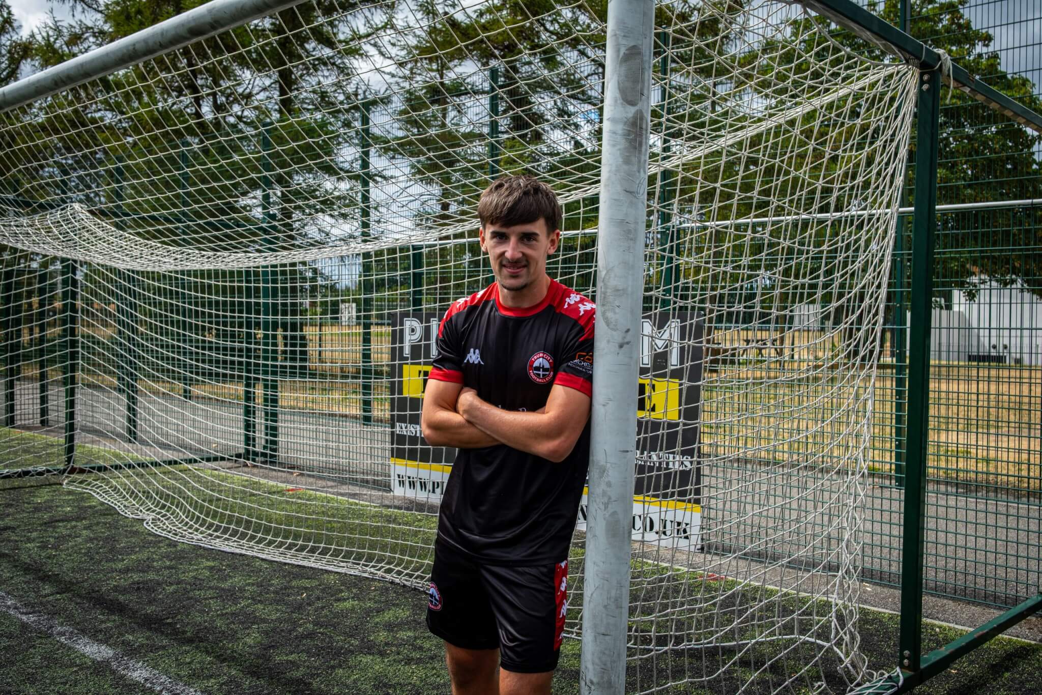 Tom Dean leaning against a goalpost in Truro City training kit