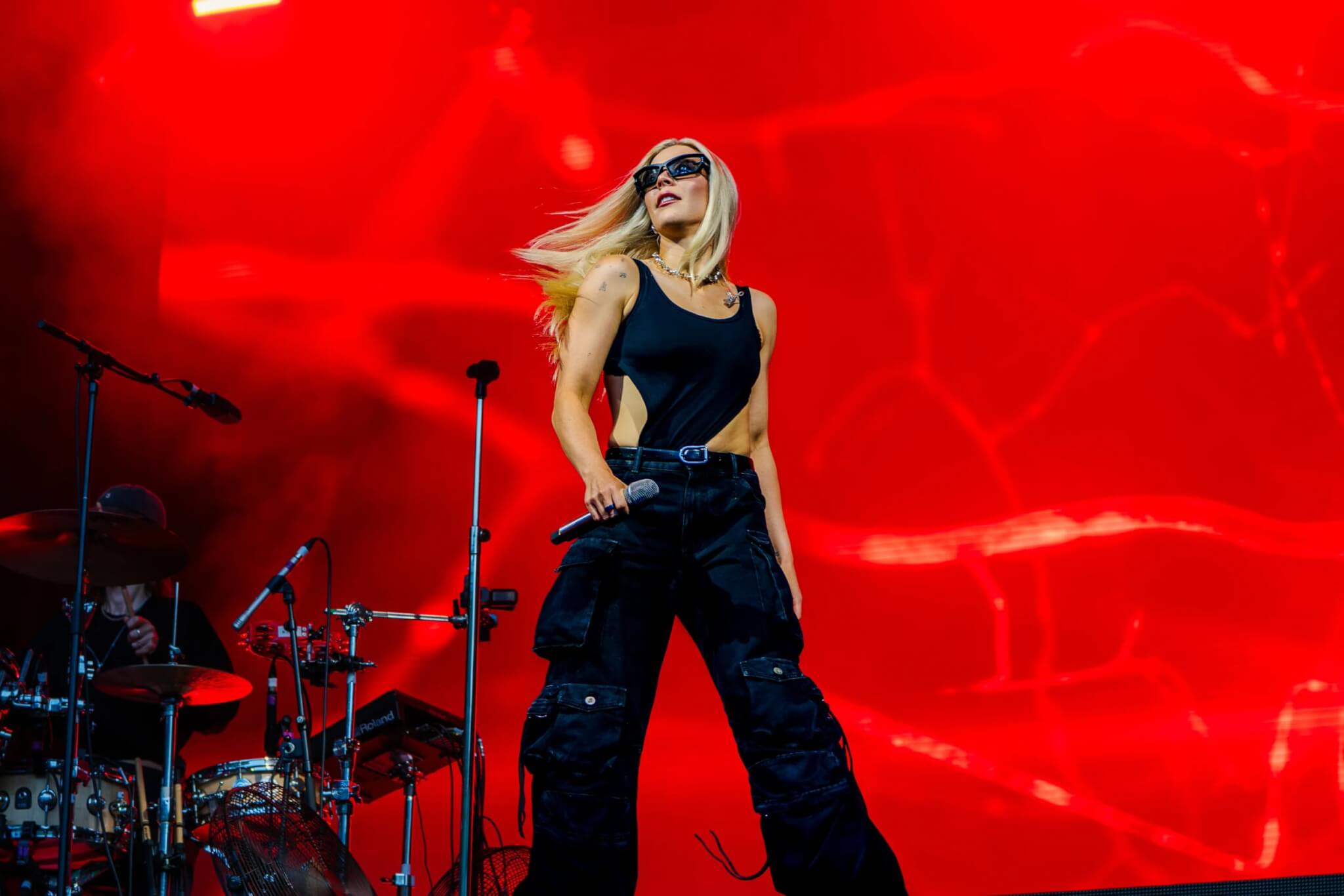 Becky Hill performing against a bold red backdrop at the Eden Sessions (photo Rob Donald)