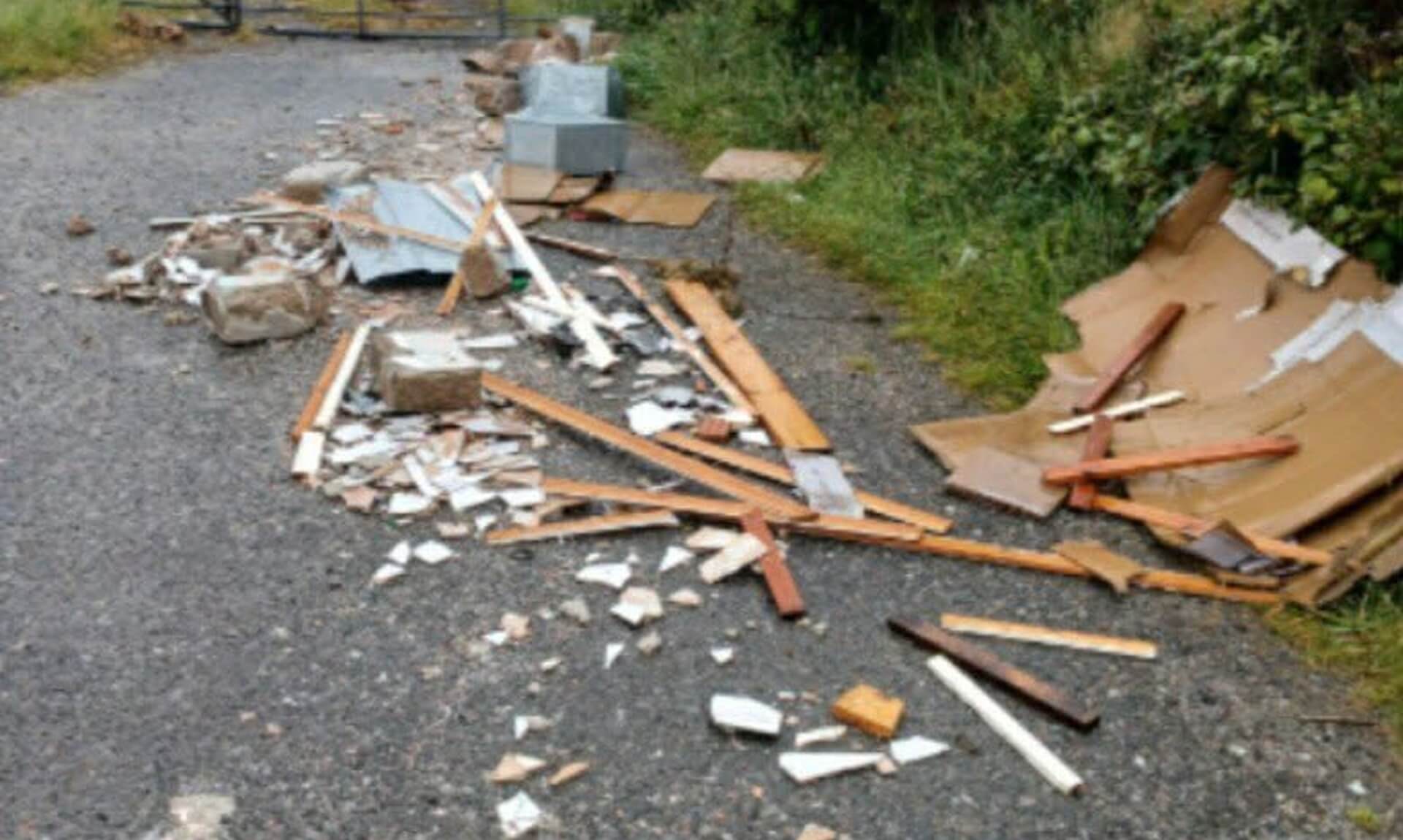 Wood, tiles and concrete blocks fly-tipped across a gravel track at Belowda near Roche