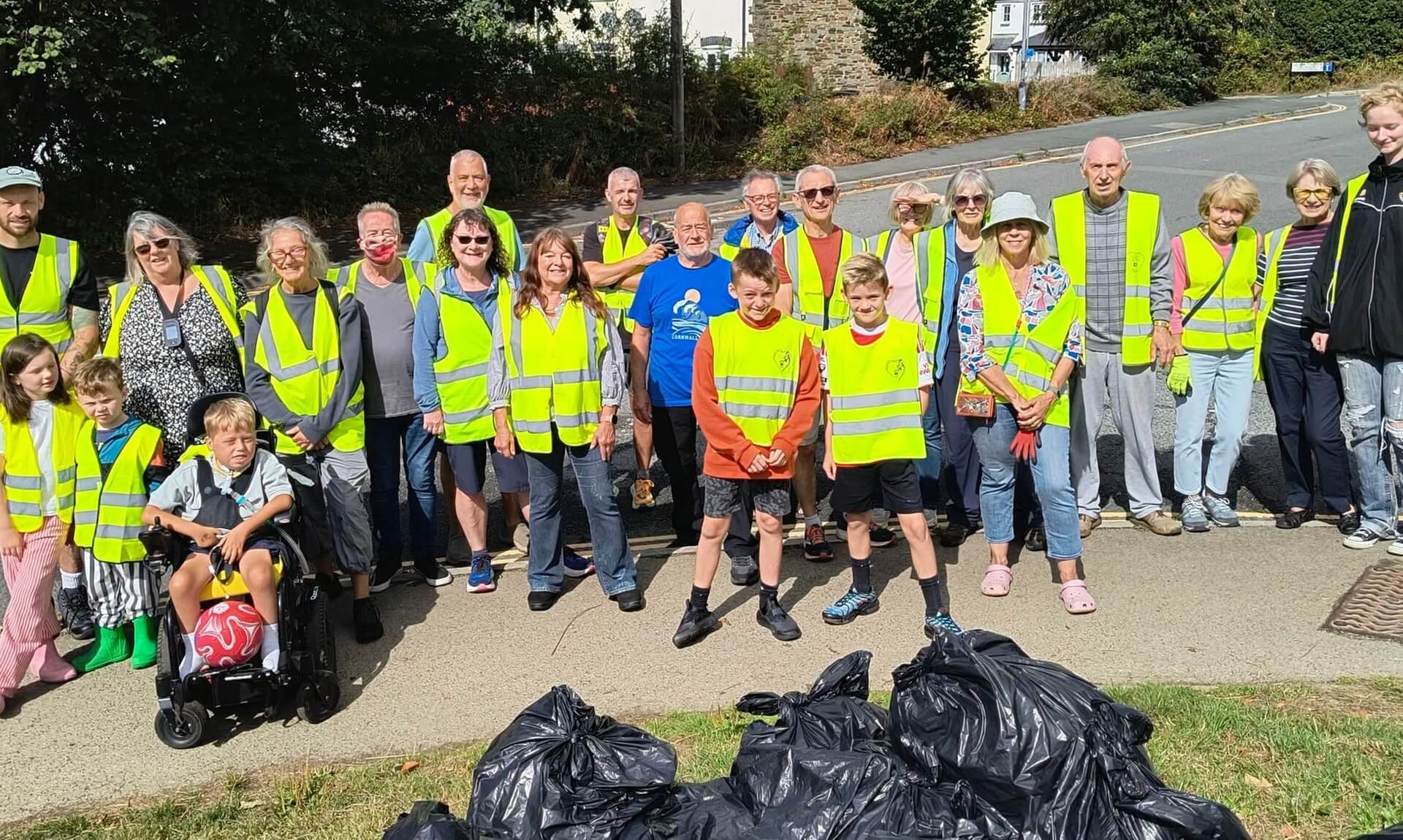Bodmin Tidy It Team volunteers in hi-vis vests with bags of rubbish and recycling on College Lane
