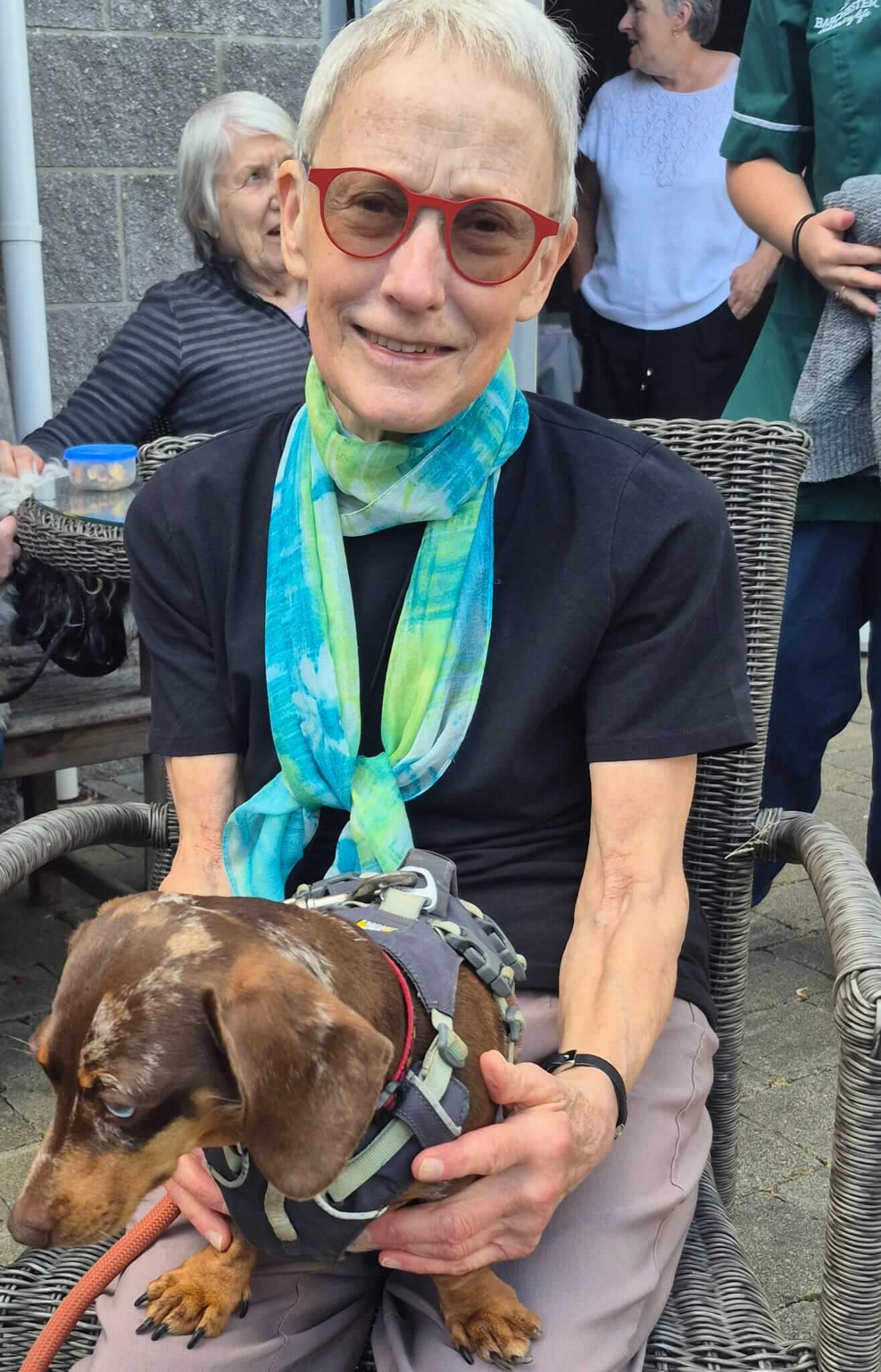 A resident at Falmouth Court Care Home holding a dachshund on the special photography day