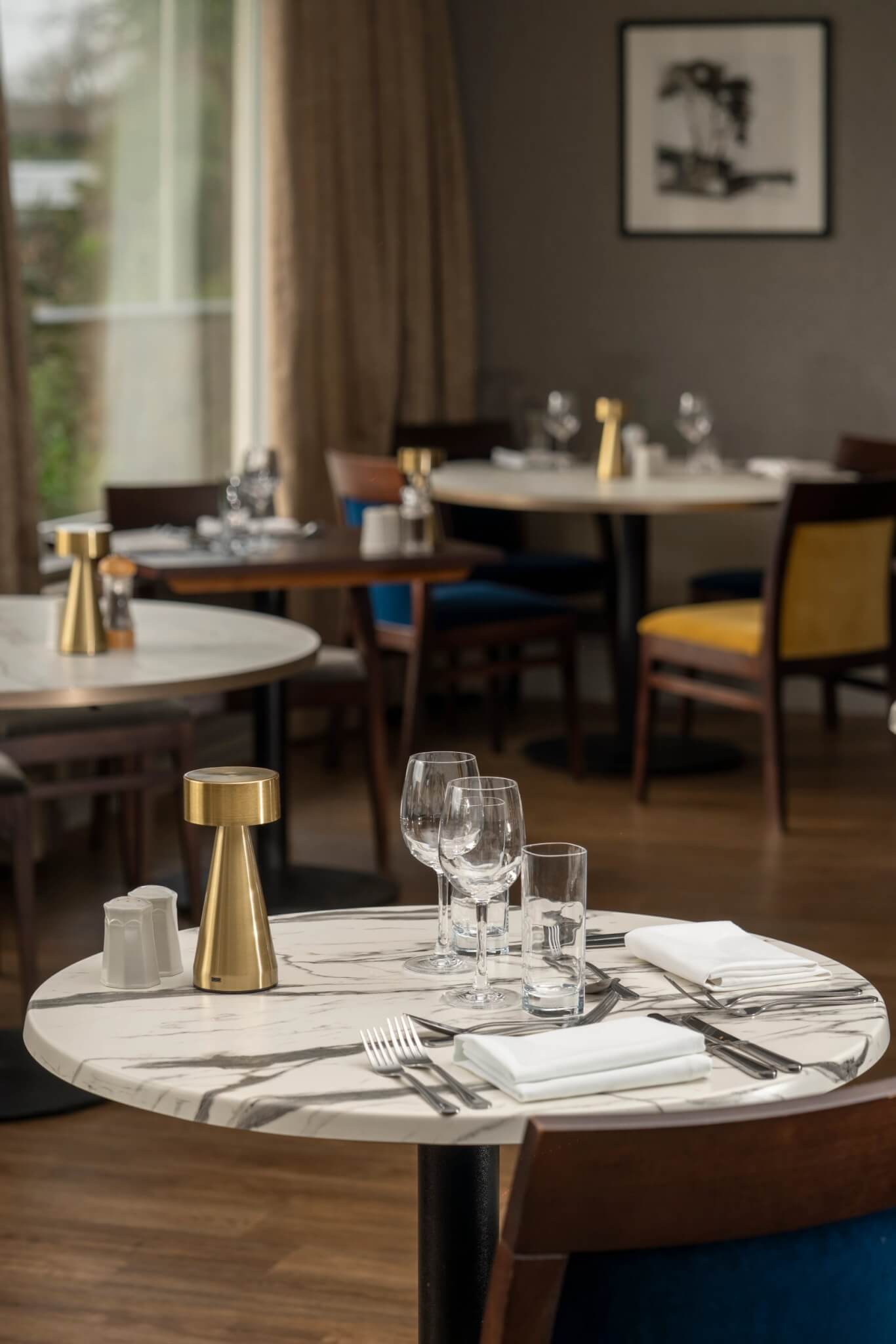 Table set with marble top, glassware and brass lamp in the restaurant