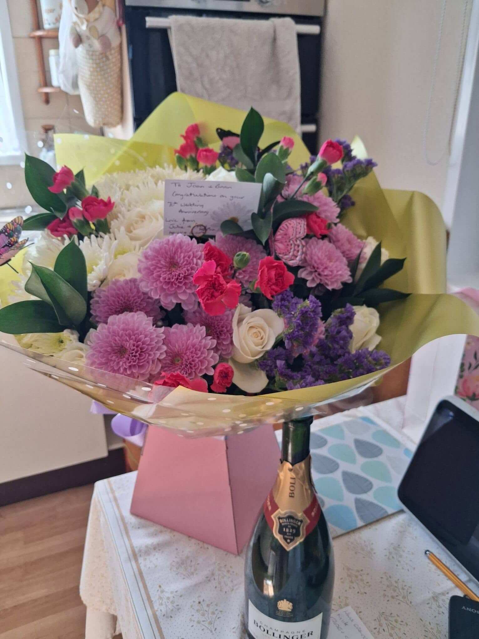 Anniversary bouquet and a bottle of Bollinger champagne in the couple's kitchen