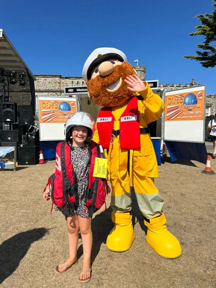 The Bude RNLI lifeboat mascot poses with a young visitor at a previous Bude Lifeboat Day