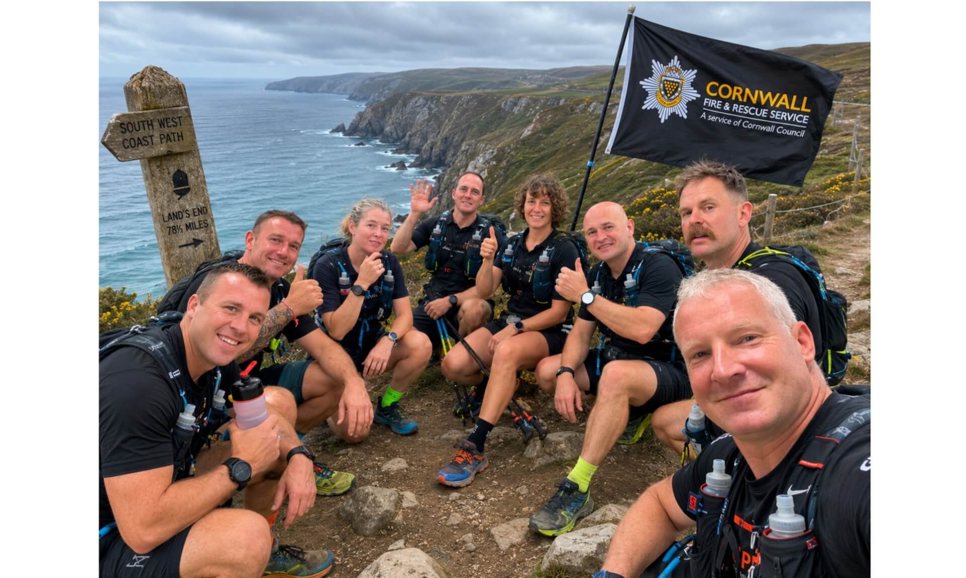 Cornwall Fire and Rescue Service runners on the South West Coast Path with a Land's End signpost