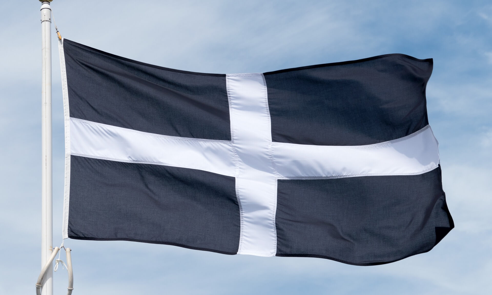 The Cornish flag, St Piran's Cross, flying against a blue sky