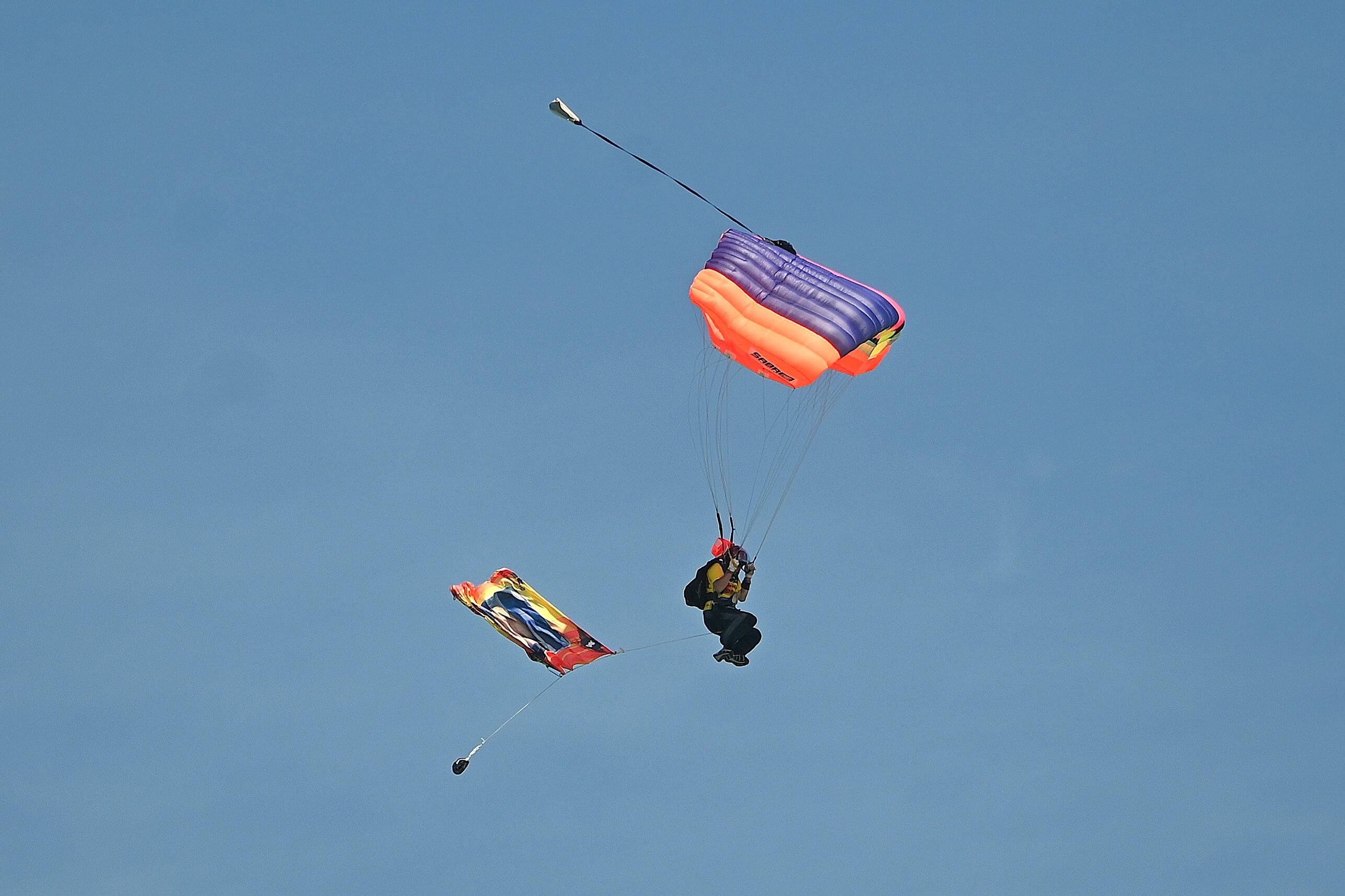 A skydiver comes in to land trailing the Joe Way flag at the Paddle for Life
