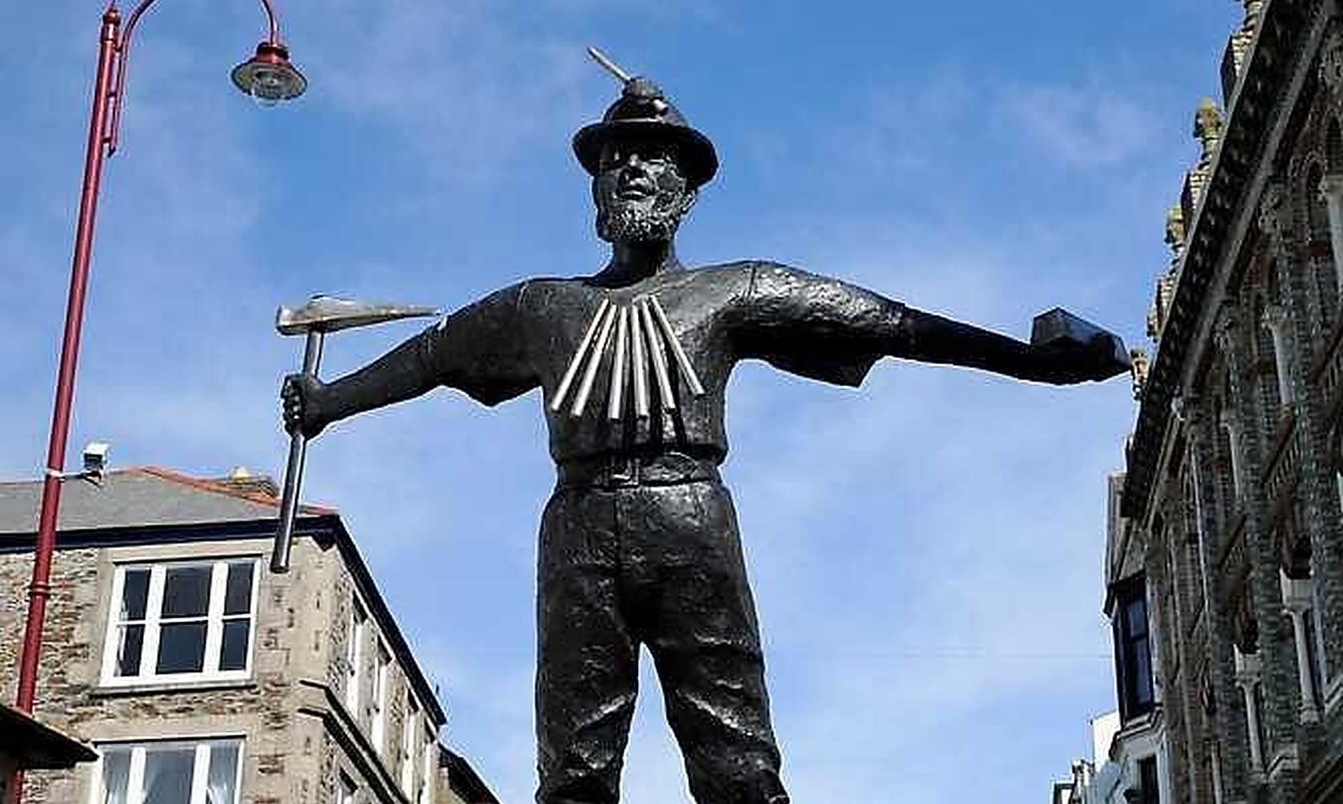 The miner statue in Camborne town centre under a blue sky