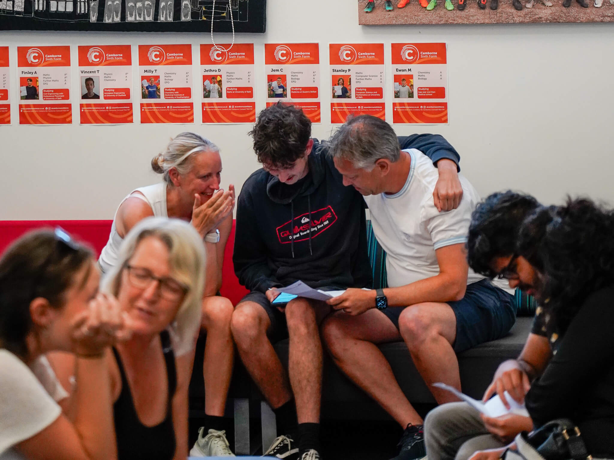 A Camborne Sixth Form student reads his A-level results alongside his family