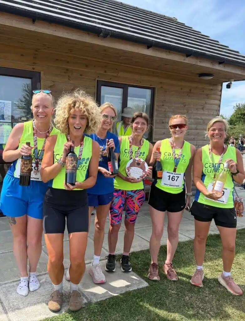 Carn Runners women's team outside the clubhouse with medals, wine and prizes after the Indian Queens Half Marathon