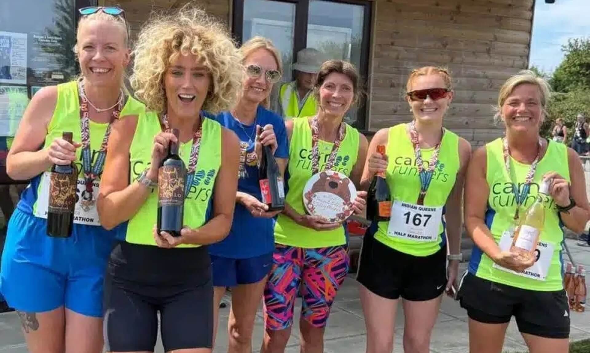 Carn Runners women's team celebrating with medals and prizes at the Indian Queens Half Marathon