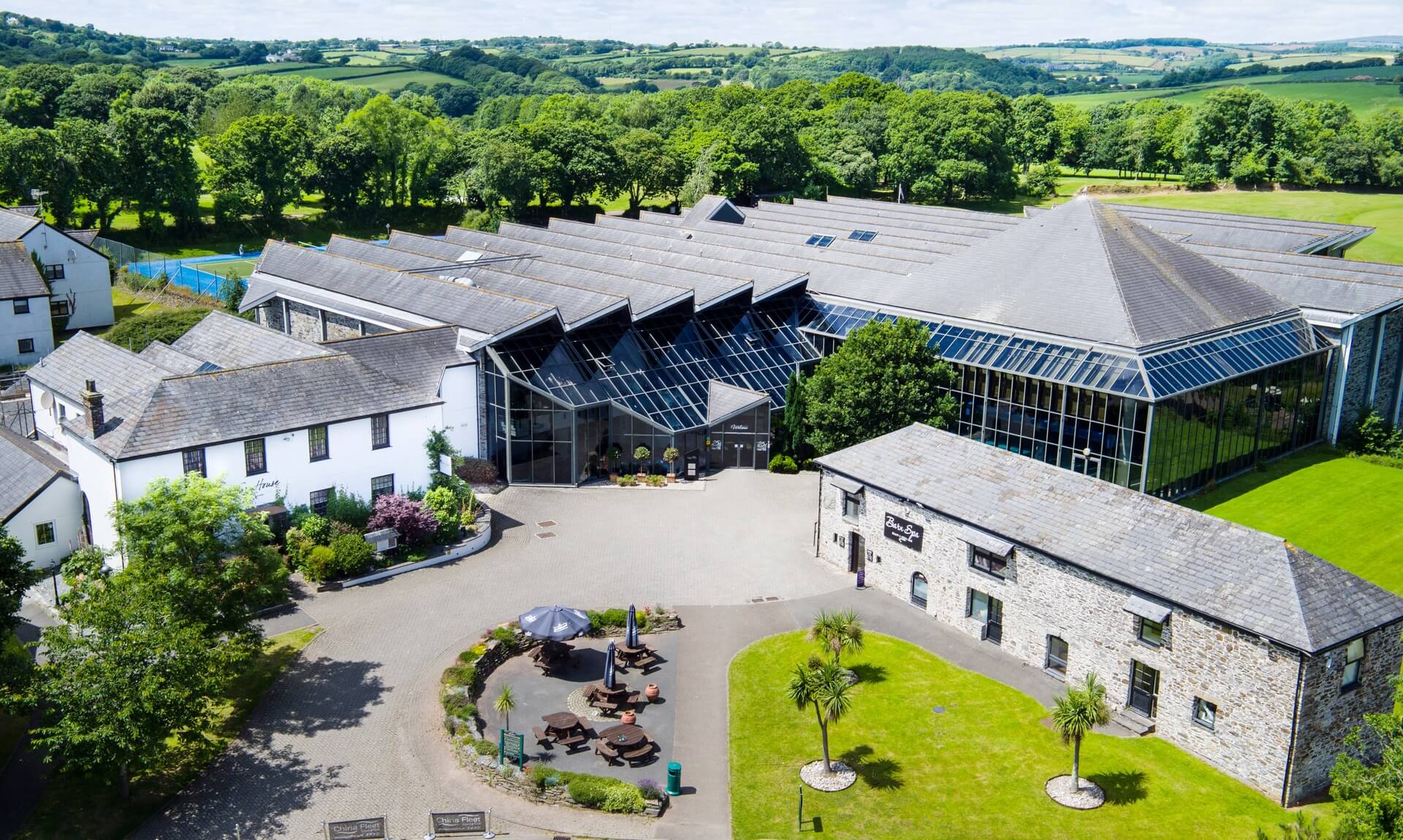 Aerial view of China Fleet Country Club at Saltash, with its glass atrium and stone spa building set in Cornish countryside